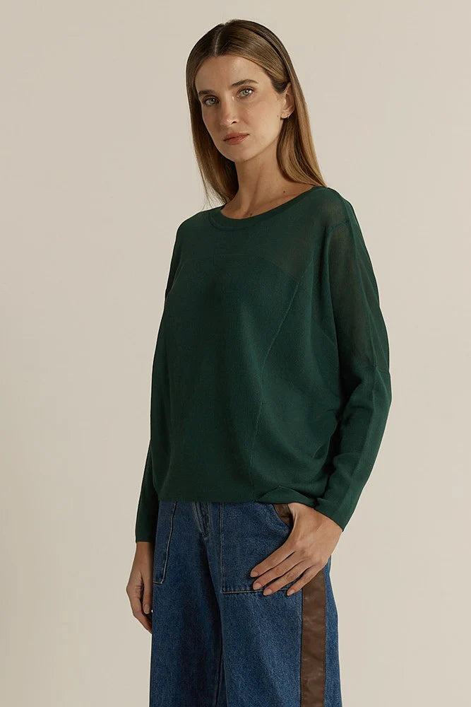 Image of Woman wearing a Fate & Becker dark green long-sleeve top against a beige background