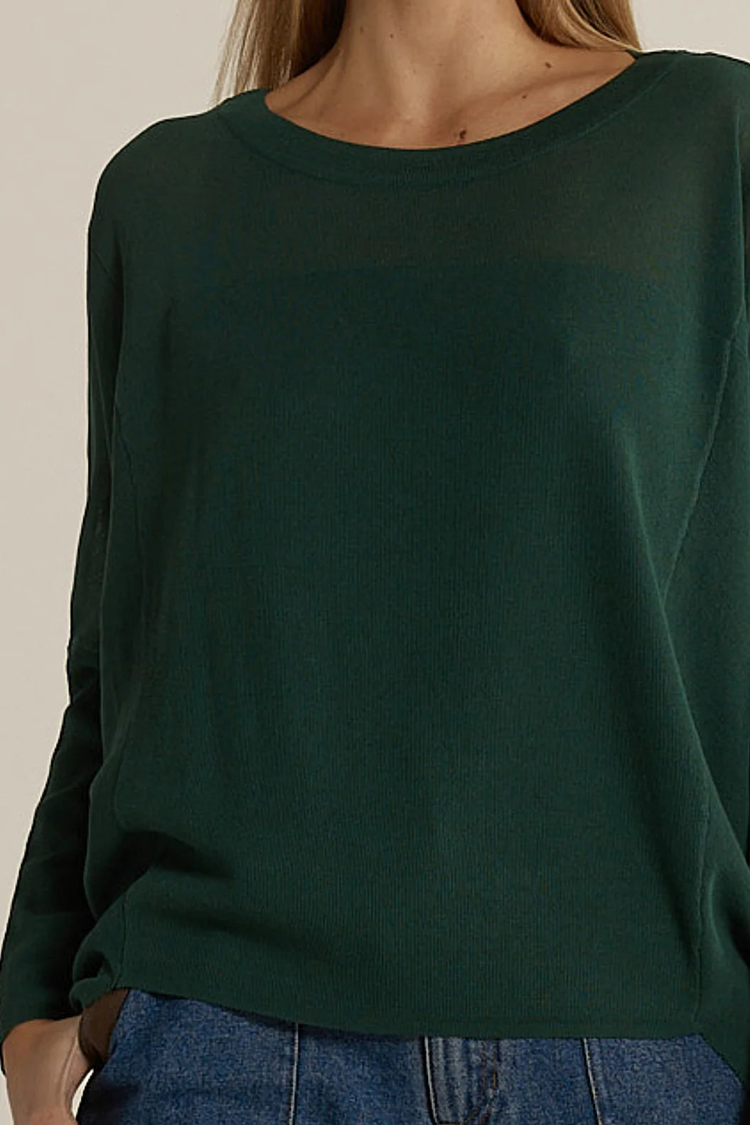 Image of Fate & Becker dark green sweater worn by a woman on a beige background