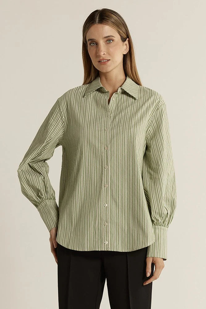 Image of Woman wearing a Fate & Becker green striped shirt against a beige background