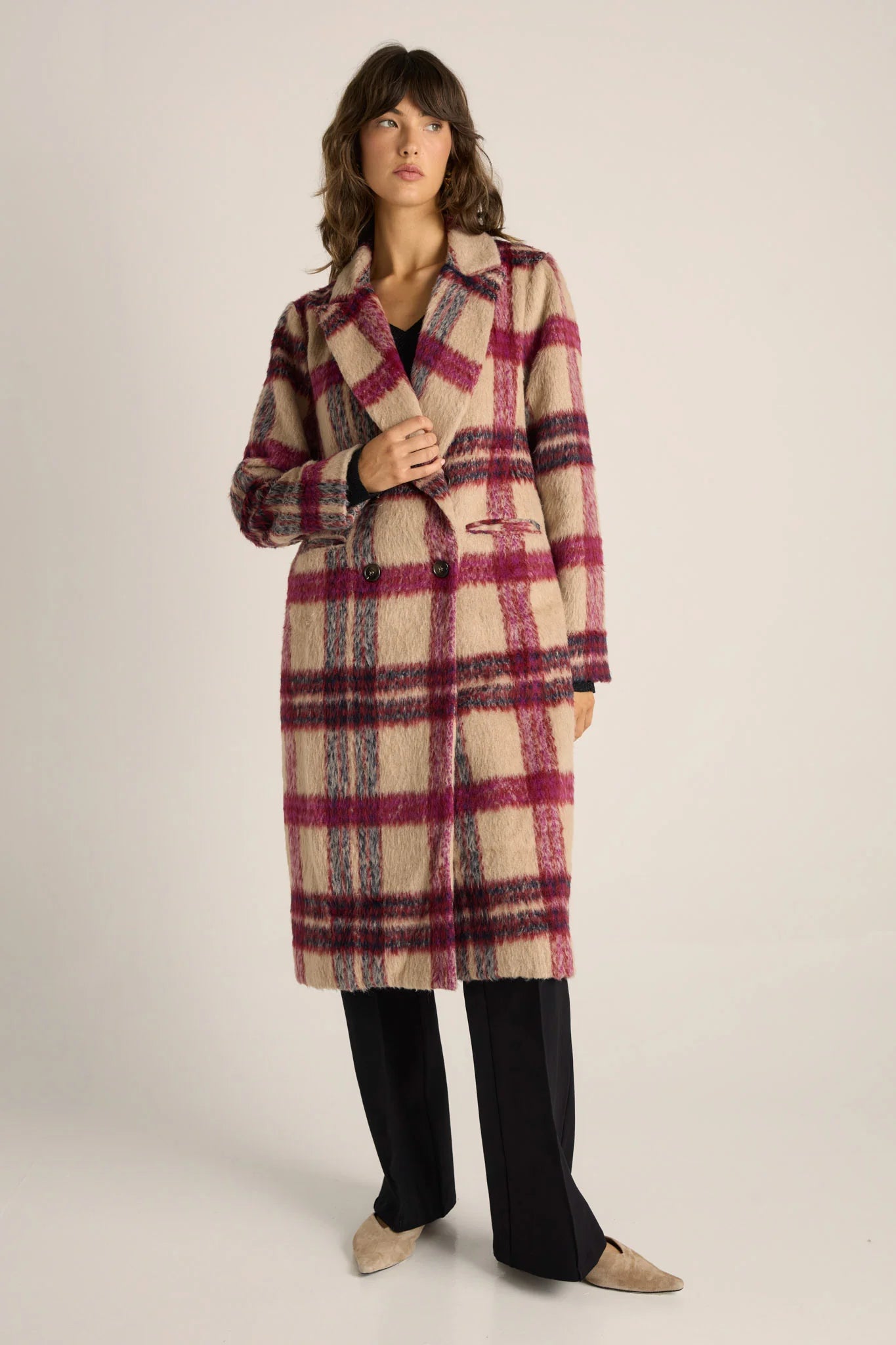 Image of Woman wearing a Fate and Becker plaid coat on a plain background