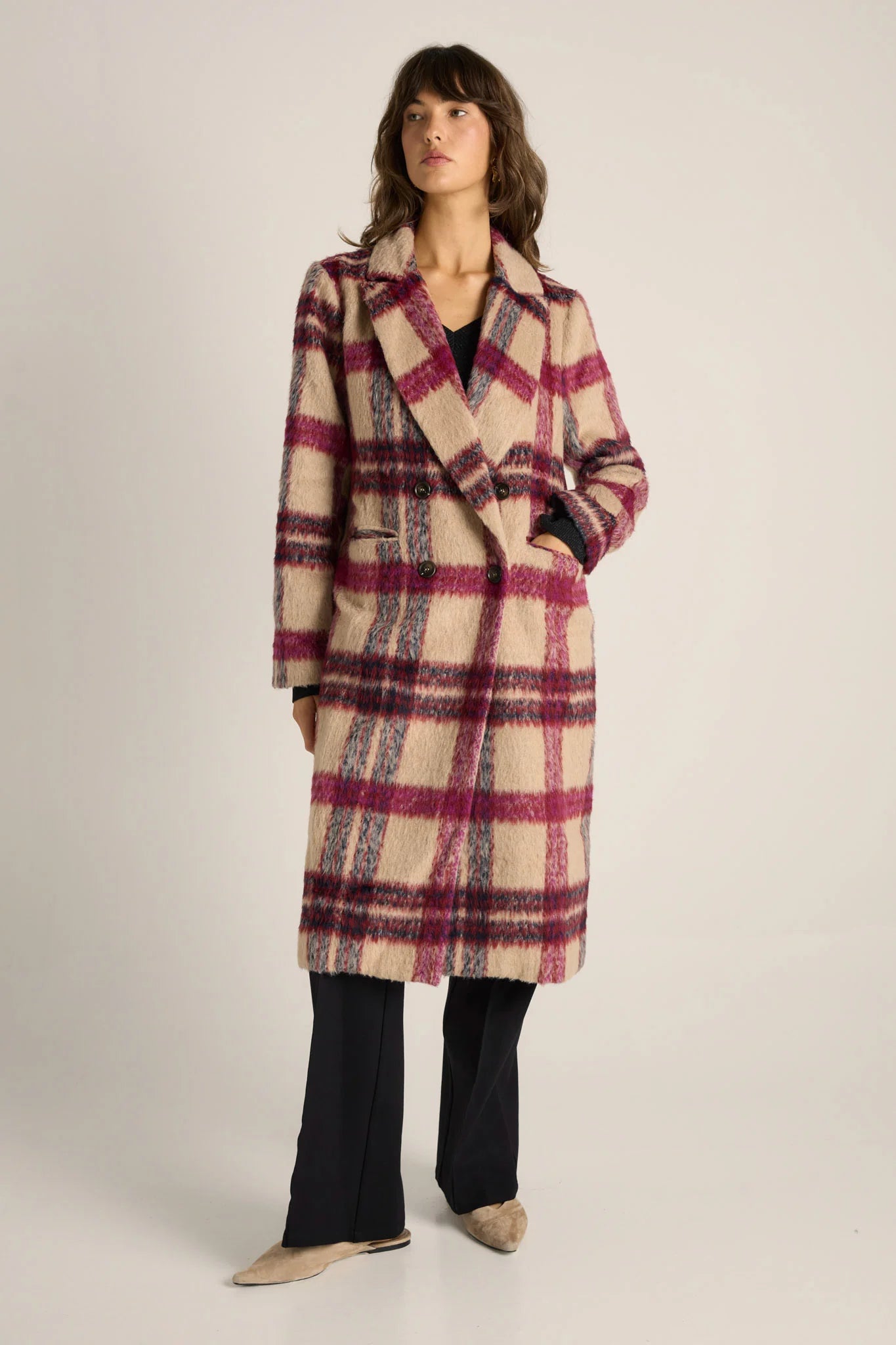 Image of Woman wearing a Fate and Becker plaid coat on a plain background