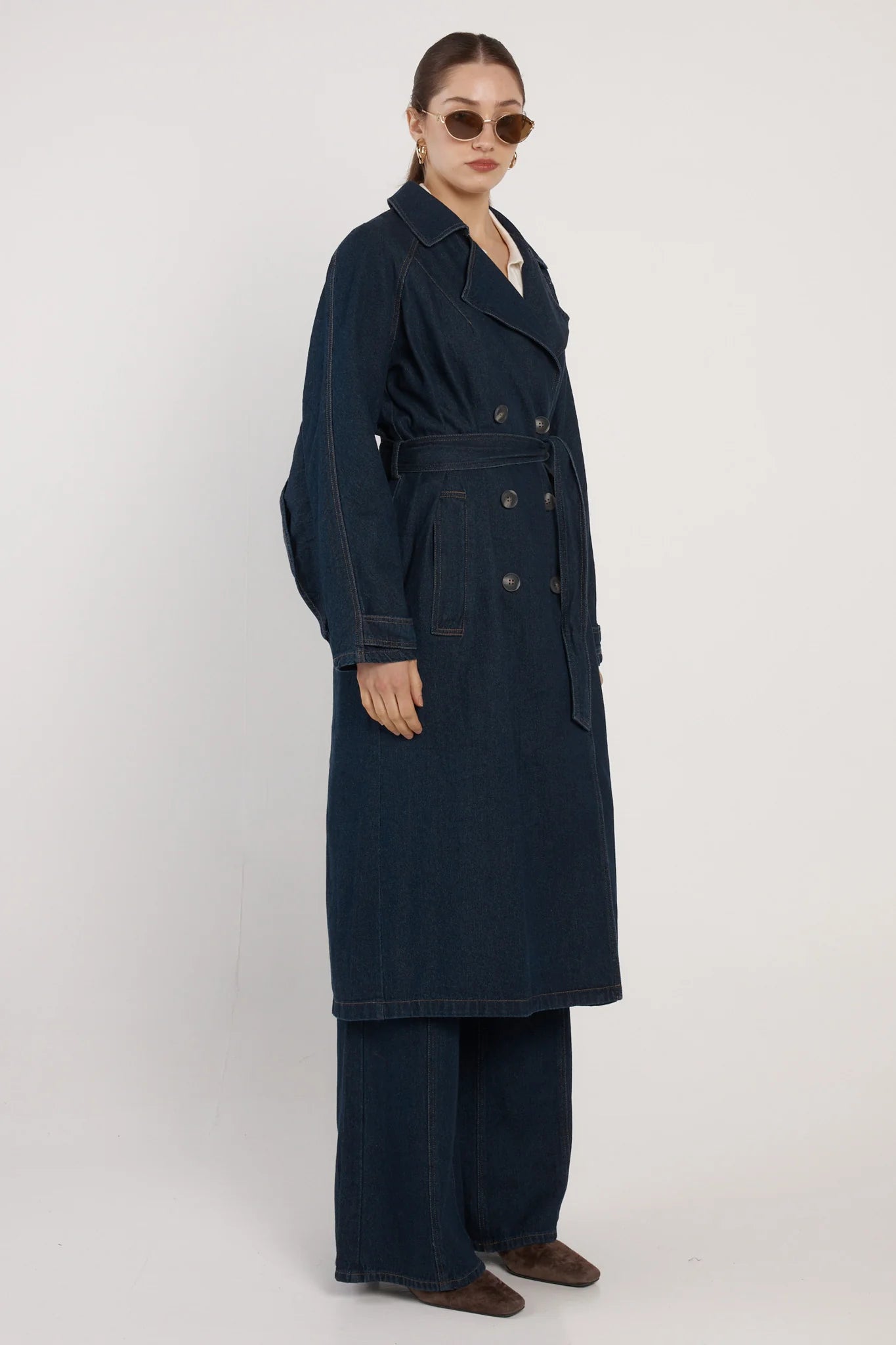 Image of Woman wearing a Fate & Becker long navy coat on a white background