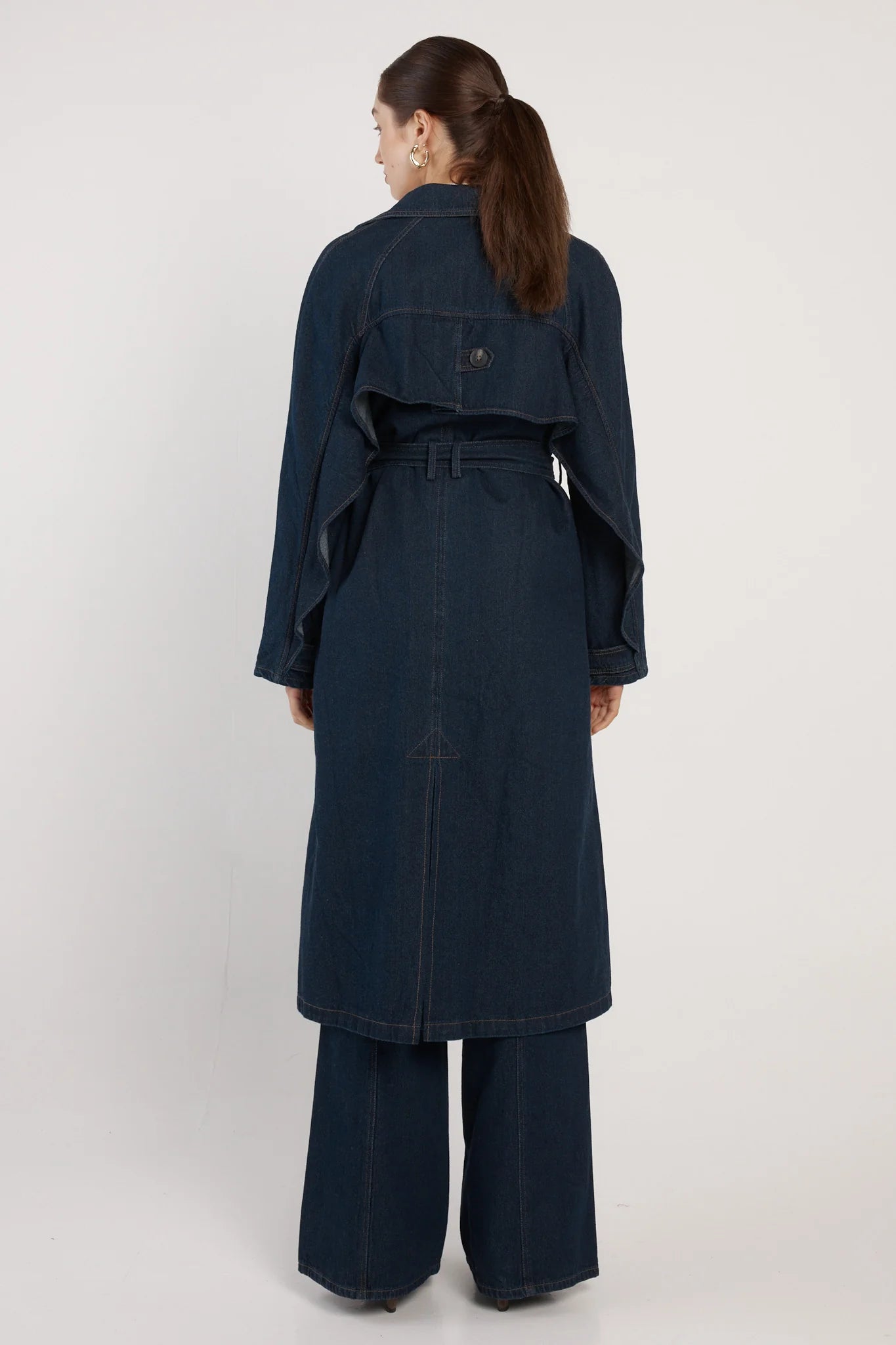 Image of Woman wearing a Fate & Becker long navy coat on a white background