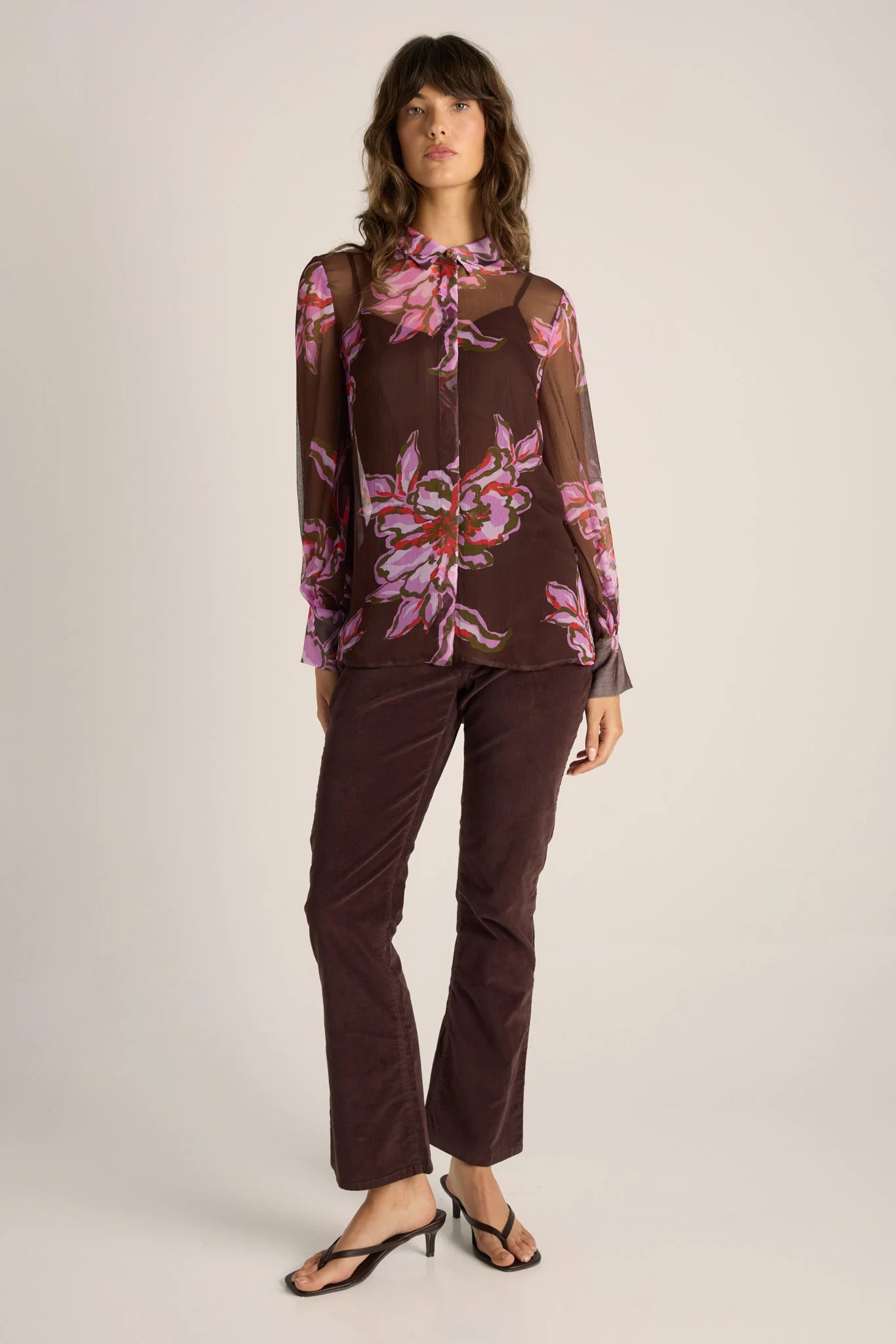 Image of Woman wearing a Fate and Becker brown floral blouse and pants on a white background