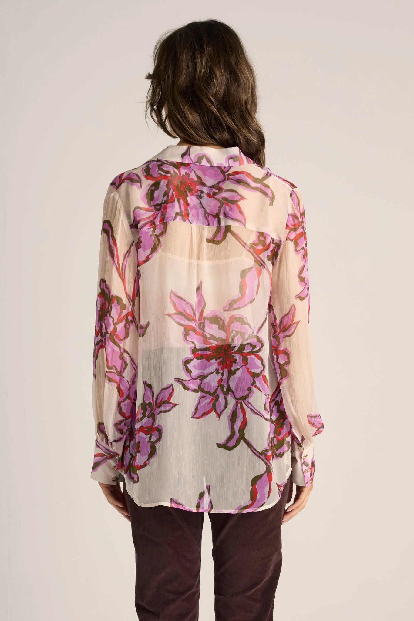 Image of Woman wearing a Fate & Becker floral blouse with a plain background
