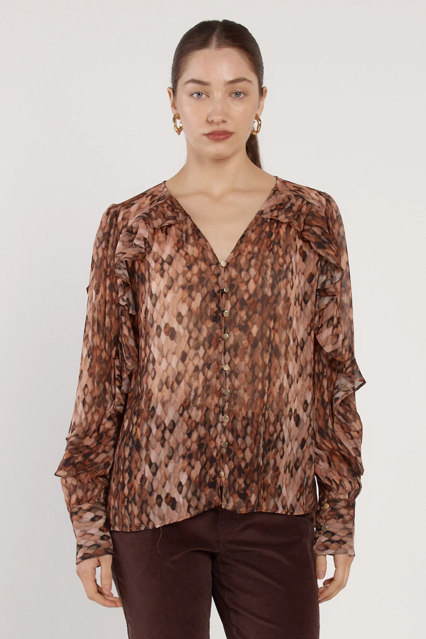 Image of Woman wearing a Fate & Becker patterned blouse against a plain background