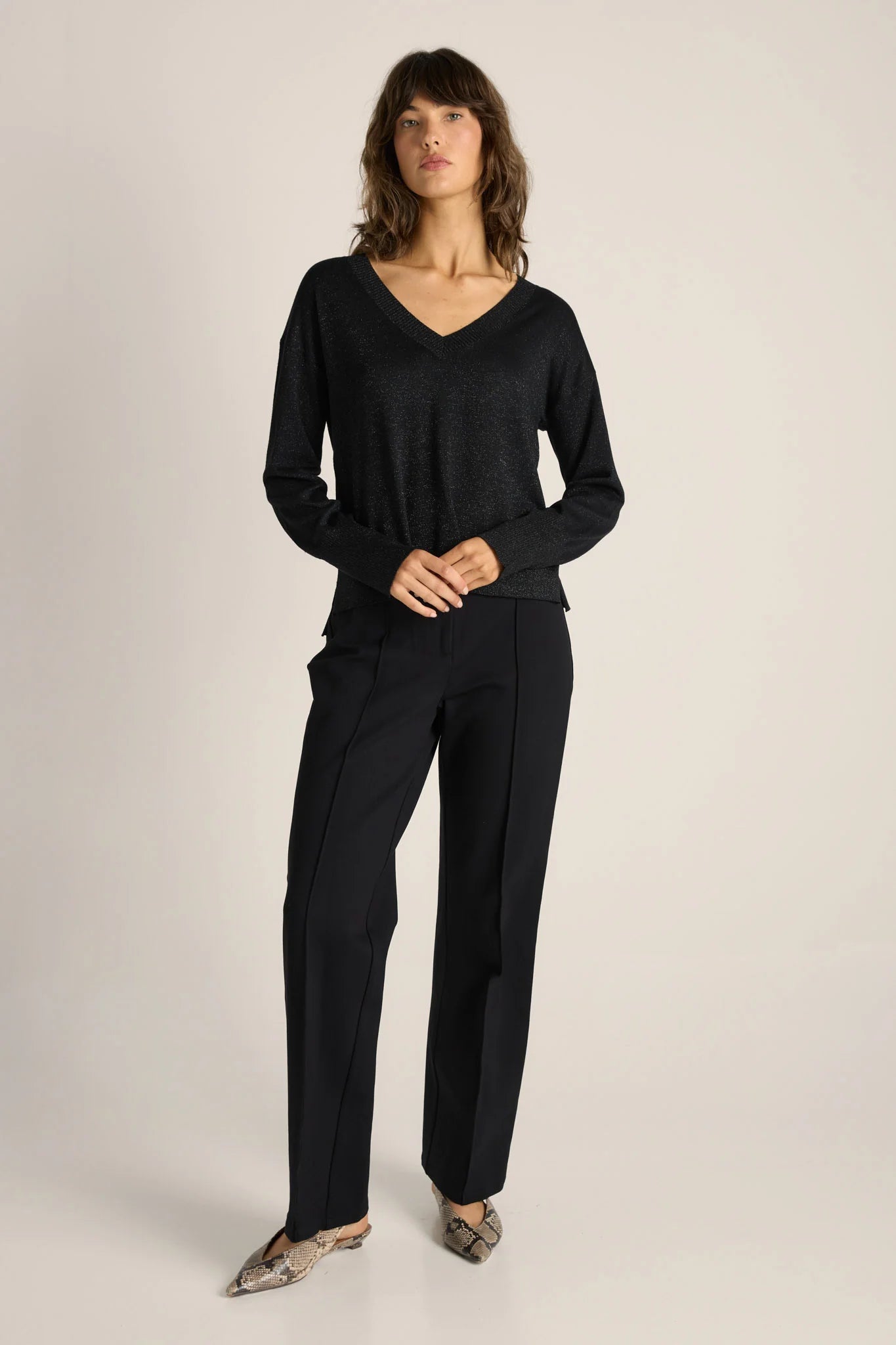 Woman wearing a Fate & Becker black outfit on a plain backgroun