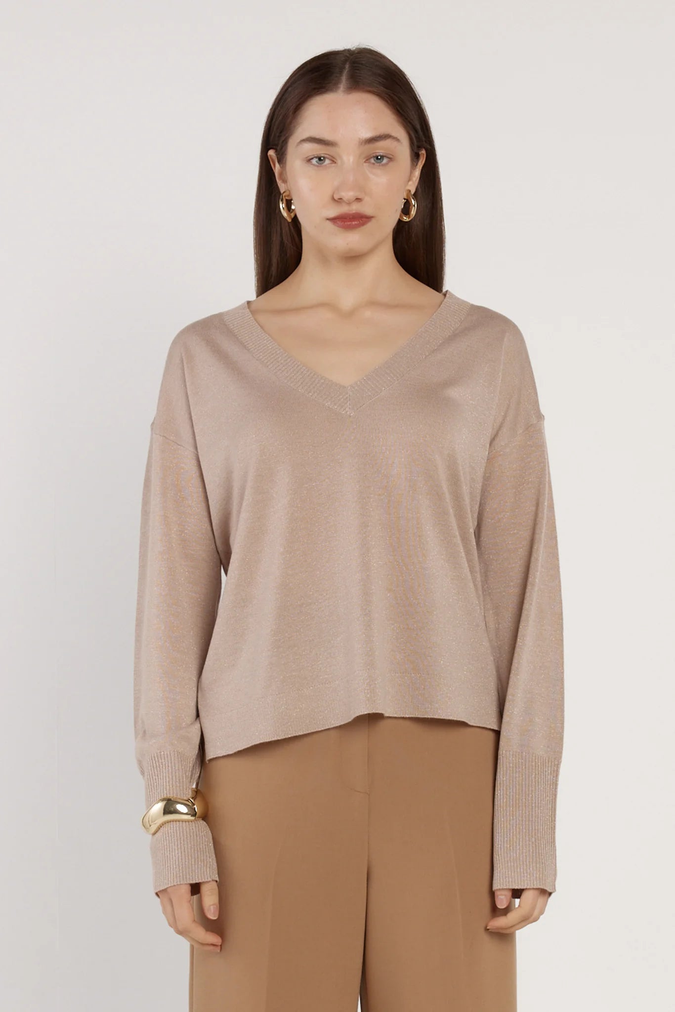 Image of Woman wearing a Fate & Becker beige sweater and pants against a white background