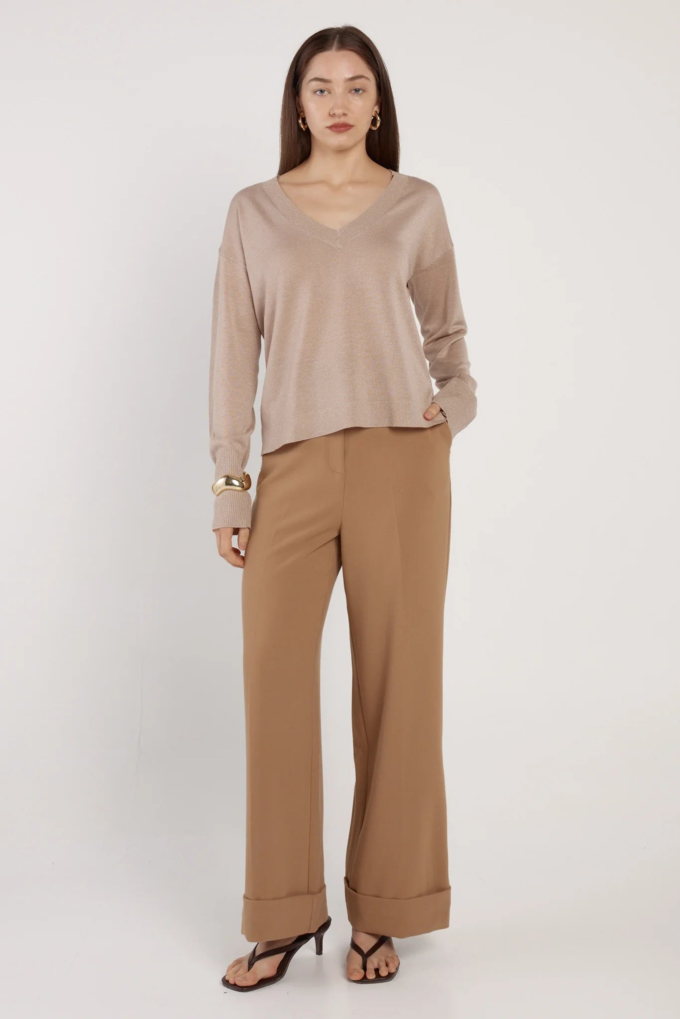 Image of Woman wearing a Fate & Becker beige long-sleeve top and tan pants on a white background