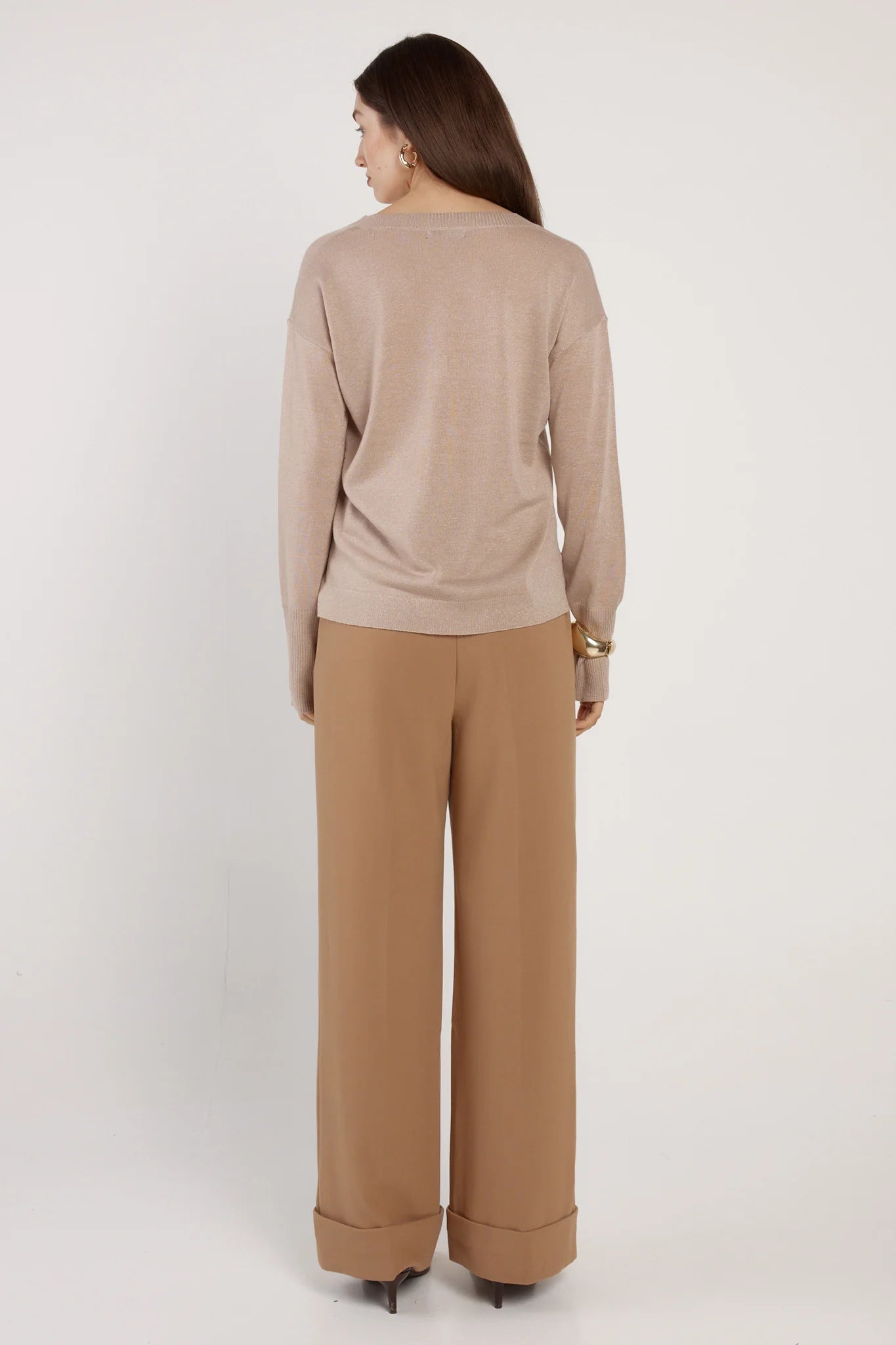 Woman wearing a Fate & Becker beige sweater and tan pants on a white background