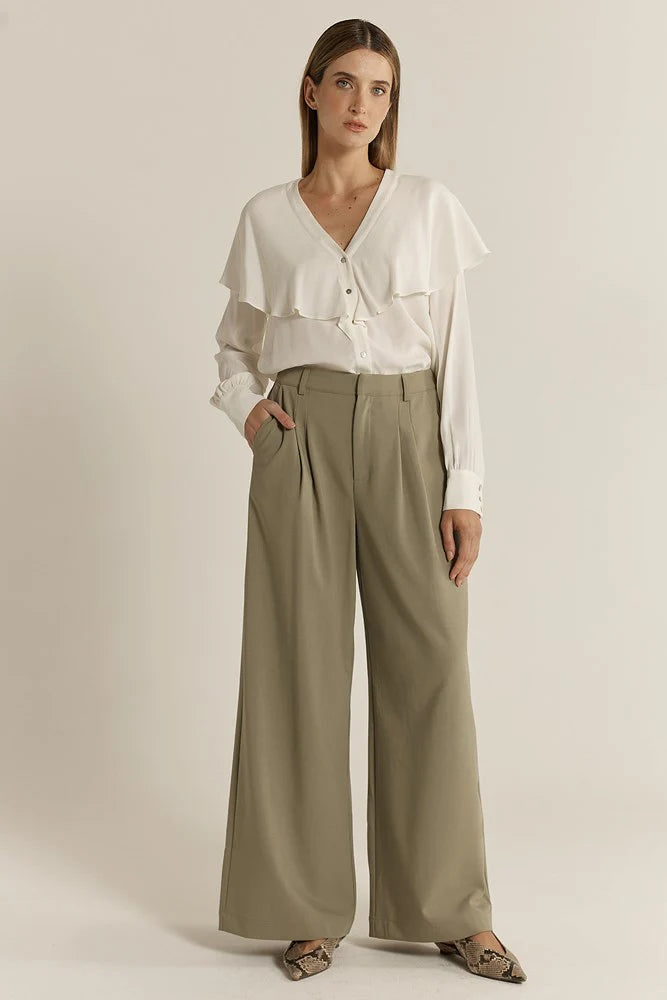 Image of Woman wearing a white blouse and Fate & Becker sage wide-leg pants on a plain background