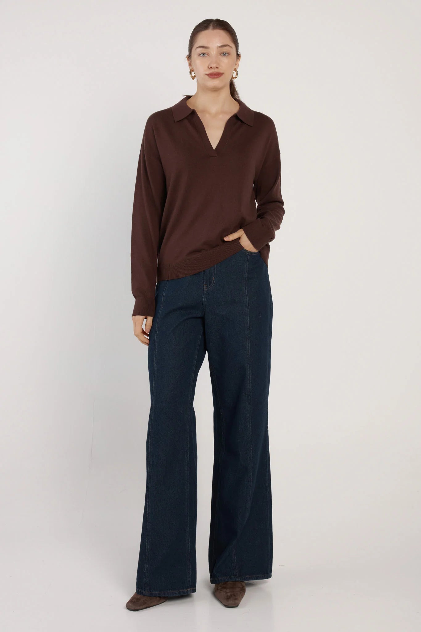 Image of Woman wearing a Fate and Becker brown sweater and dark blue jeans on a white background