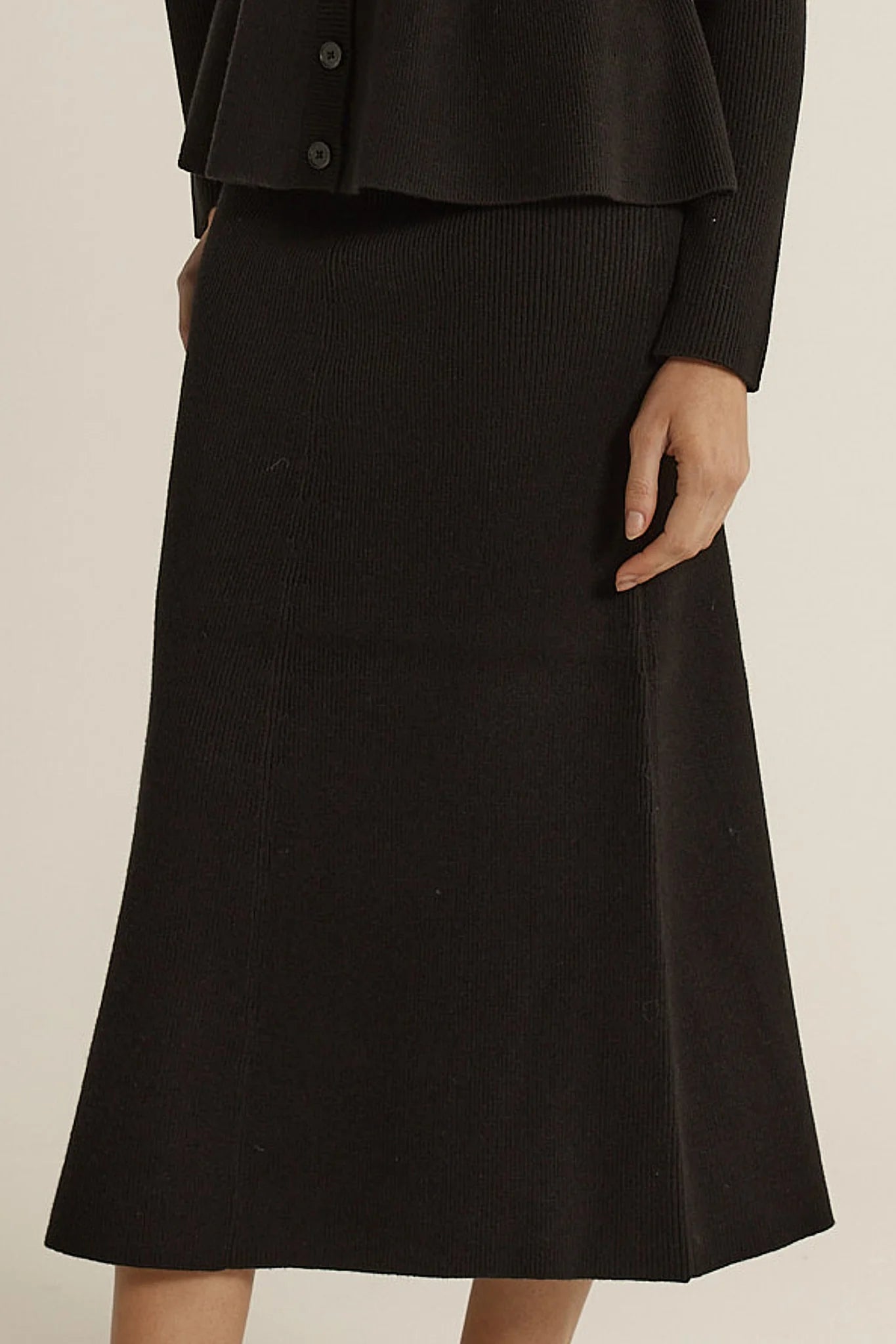 Image of Fate & Becker black skirt worn by a woman on a beige background