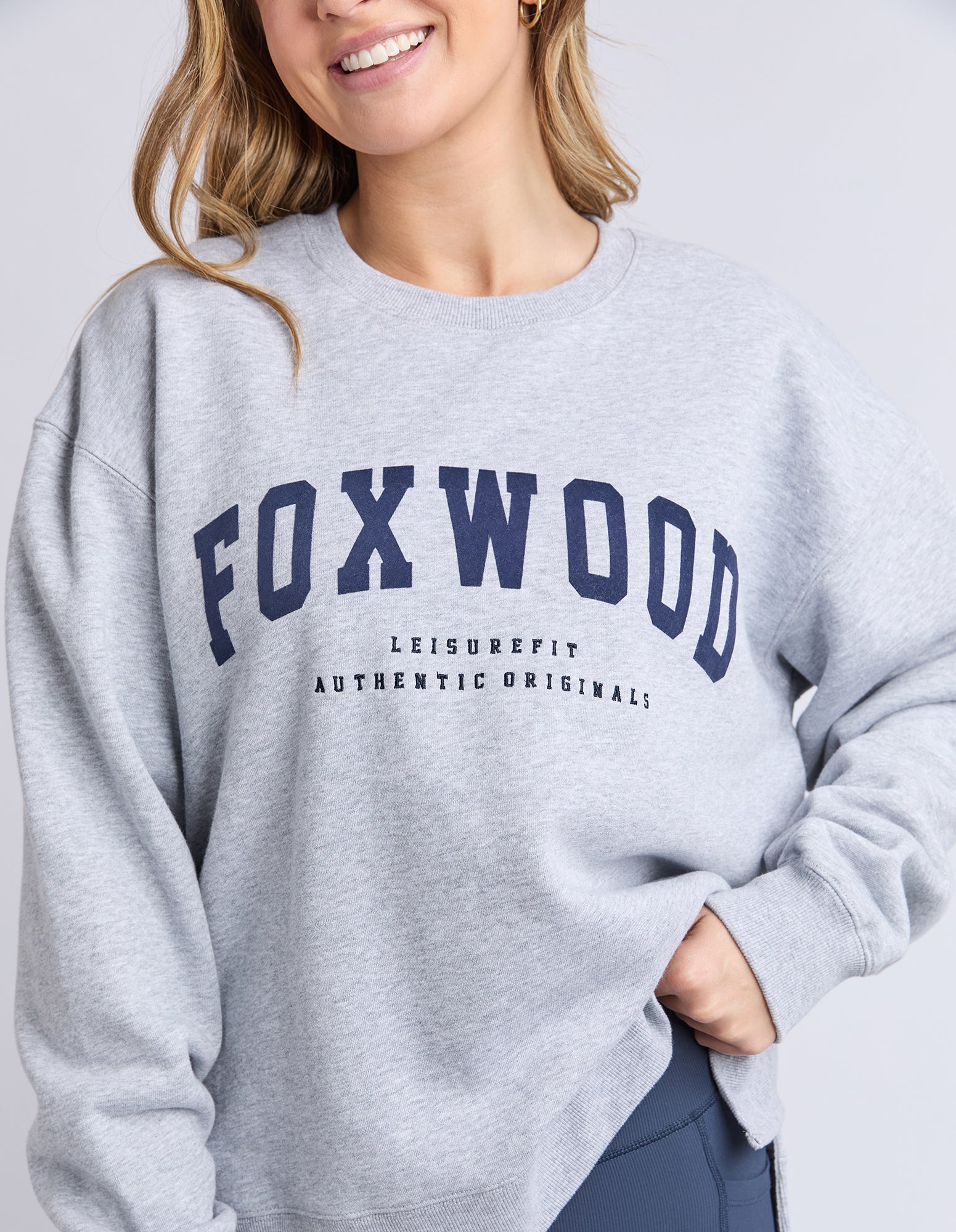 Person wearing a grey sweatshirt with 'FOXWOOD' branding