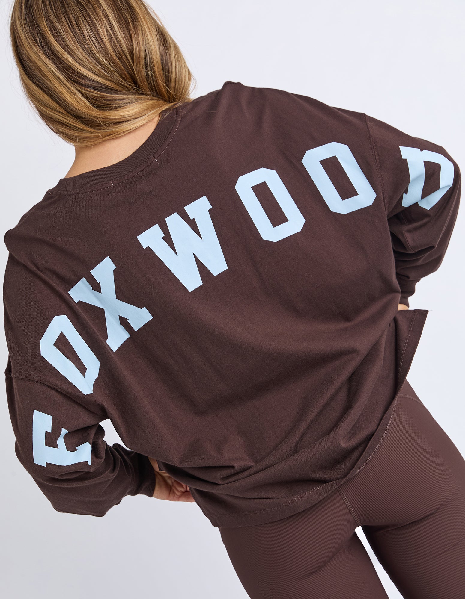 Image of Brown sweatshirt with 'FOXWOOD' printed on the back in light blue against a white background