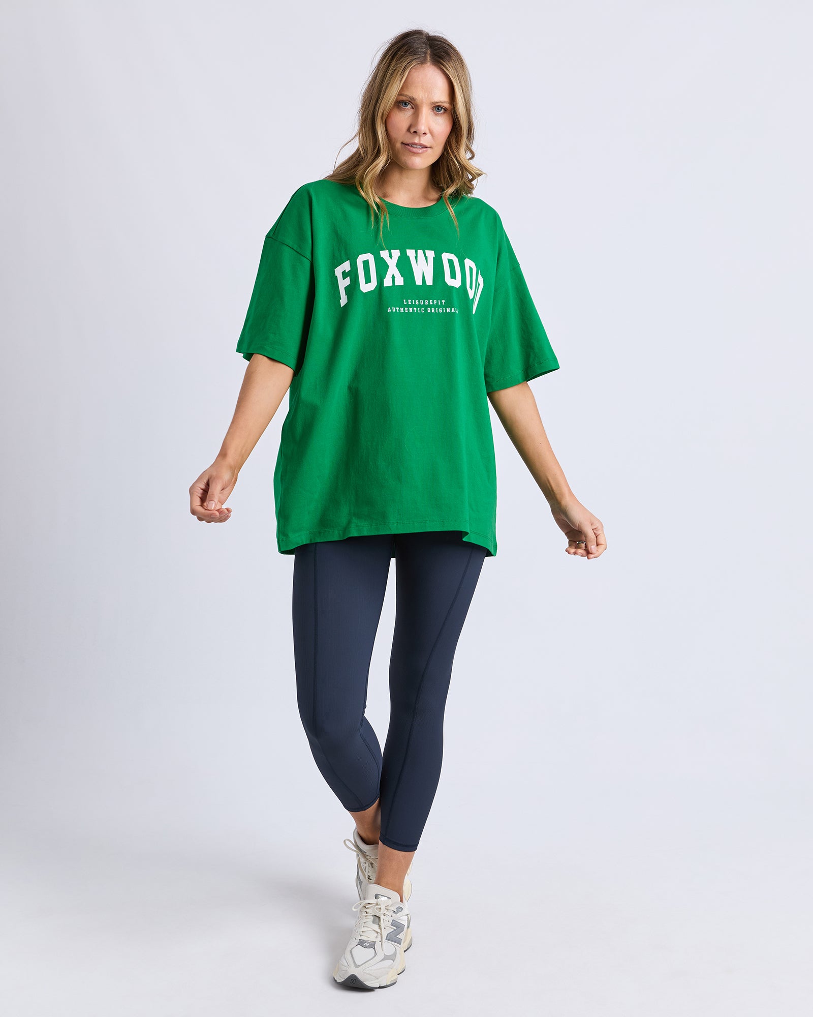 Woman wearing a green 'FOXWOOD' t-shirt with white writing on a white background