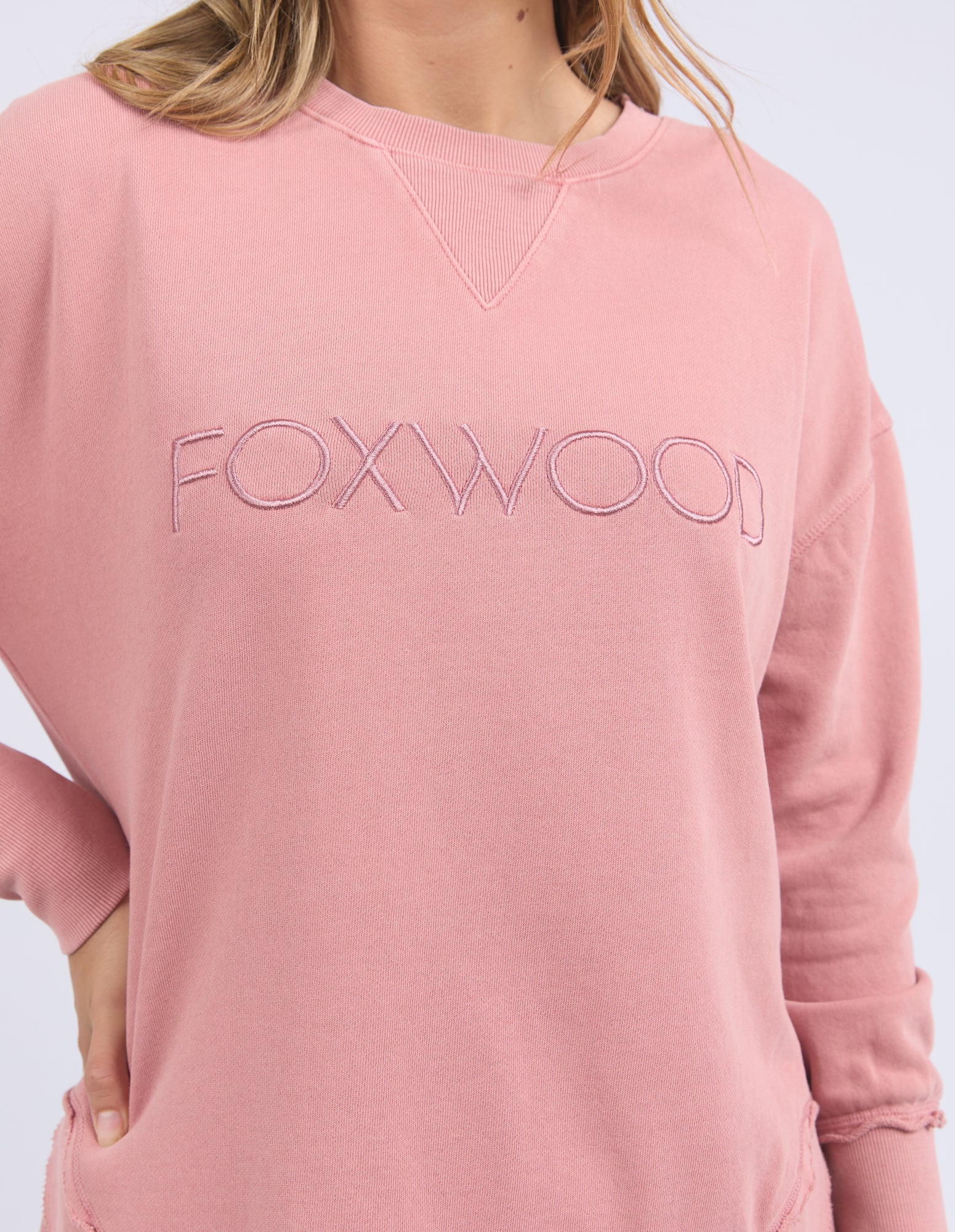 Woman wearing a Dusty Rose Jumper with 'FOXWOOD' branding on a light grey background