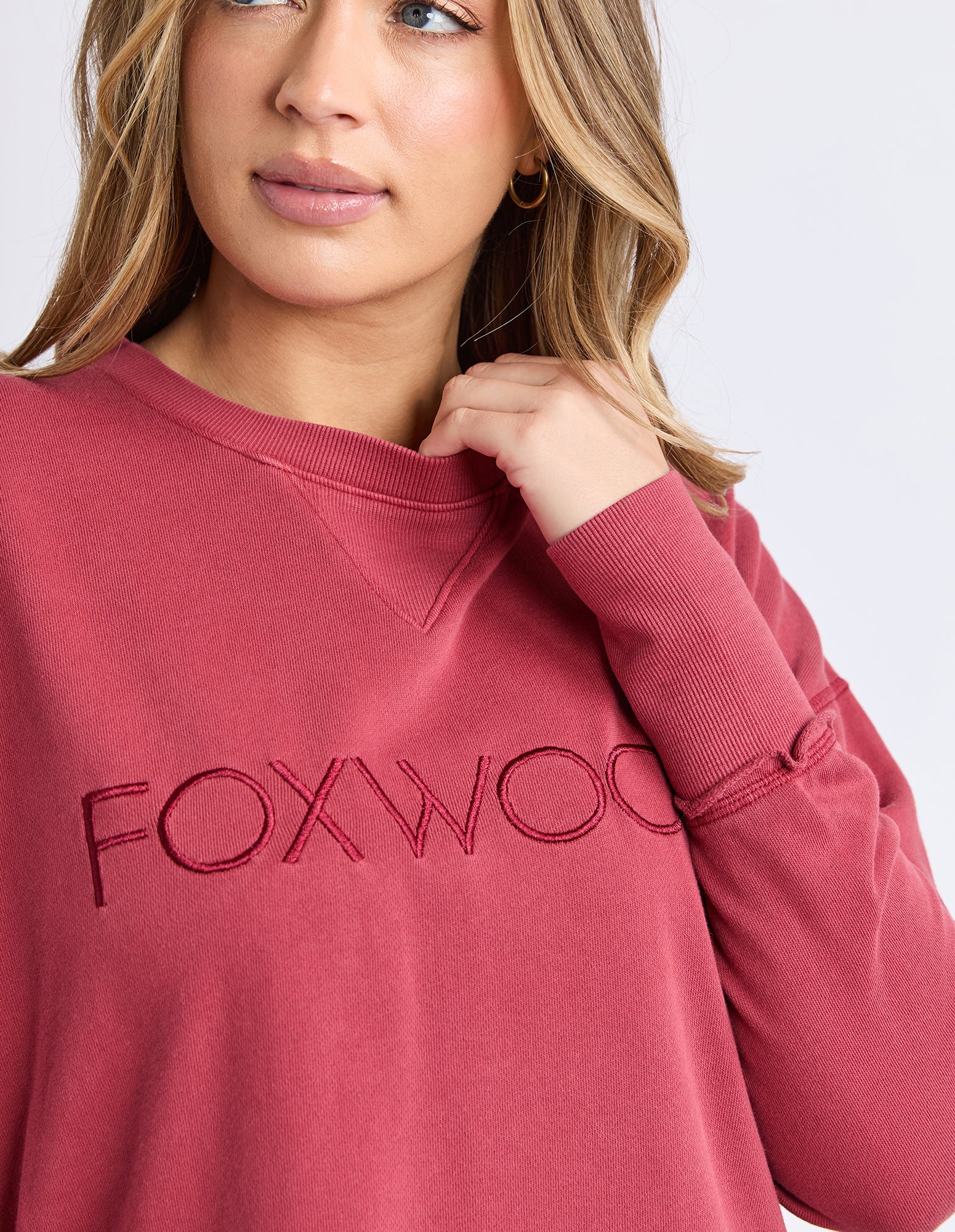 Woman wearing a jumper with 'FOXWOOD' branding on a white background