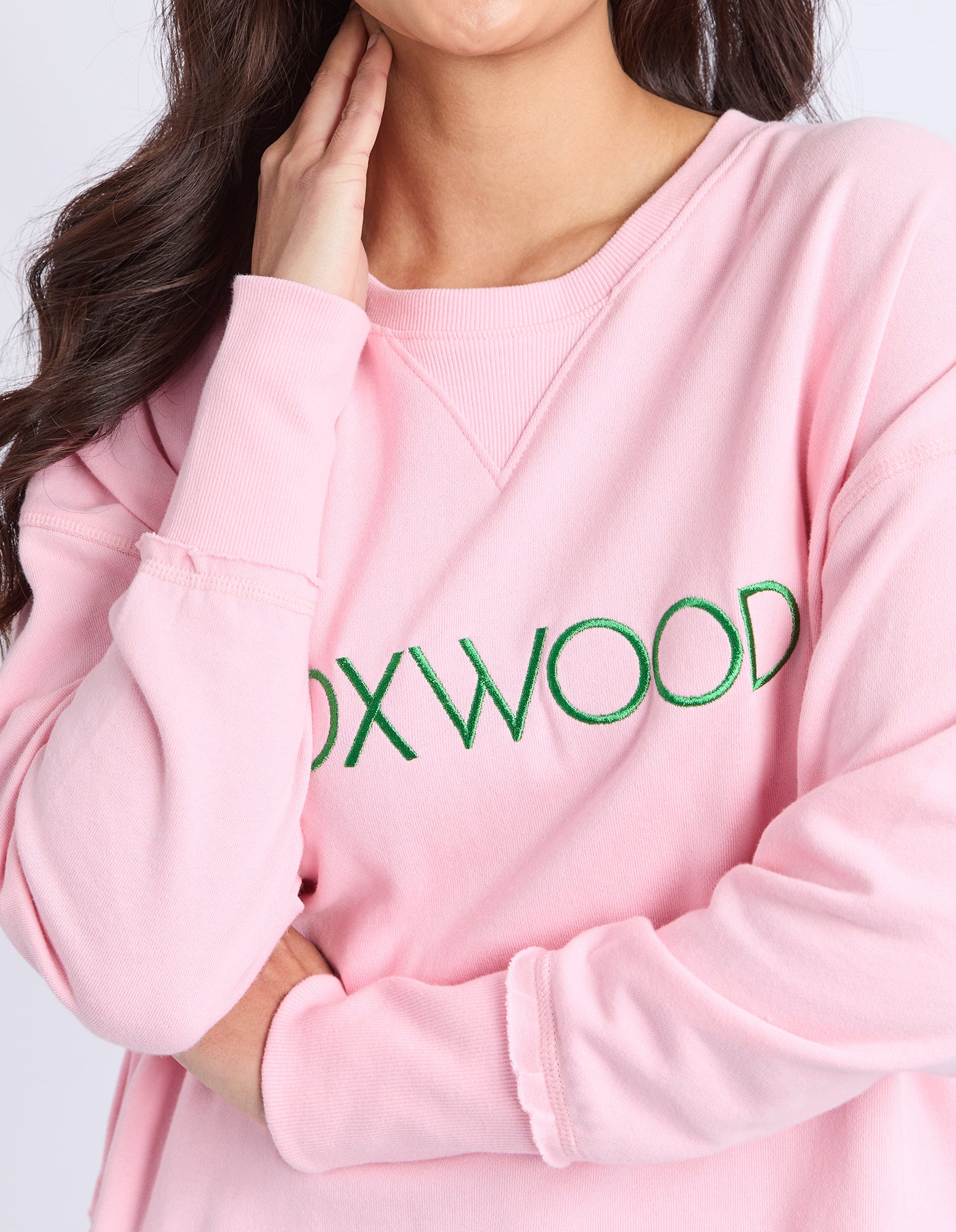 Pink jumper with 'FOXWOOD' text in green on a plain background