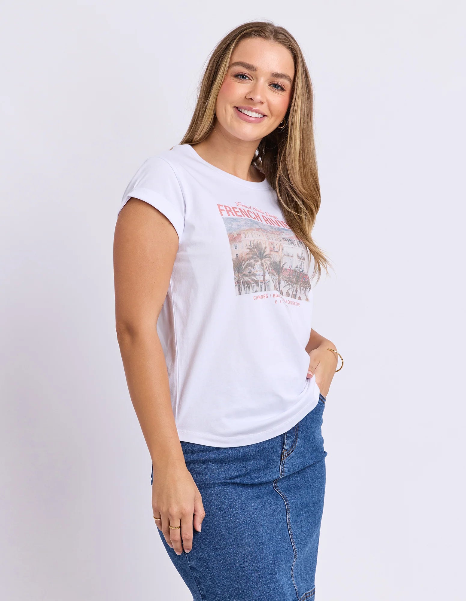 Image of Woman wearing a Foxwood white t-shirt with a graphic design on a plain background
