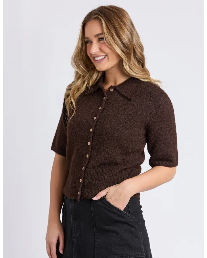 Woman wearing a Foxwood brown short-sleeve knit shirt on a plain background