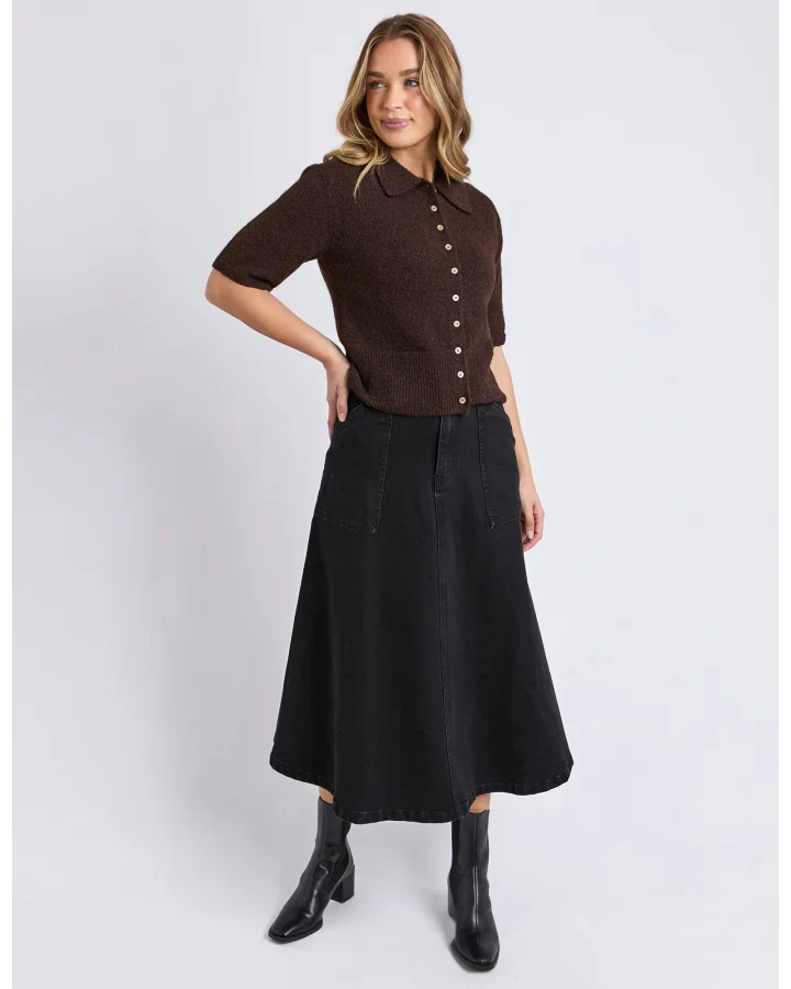 Image of Woman wearing a Foxwood brown short-sleeve shirt and black skirt on a white background