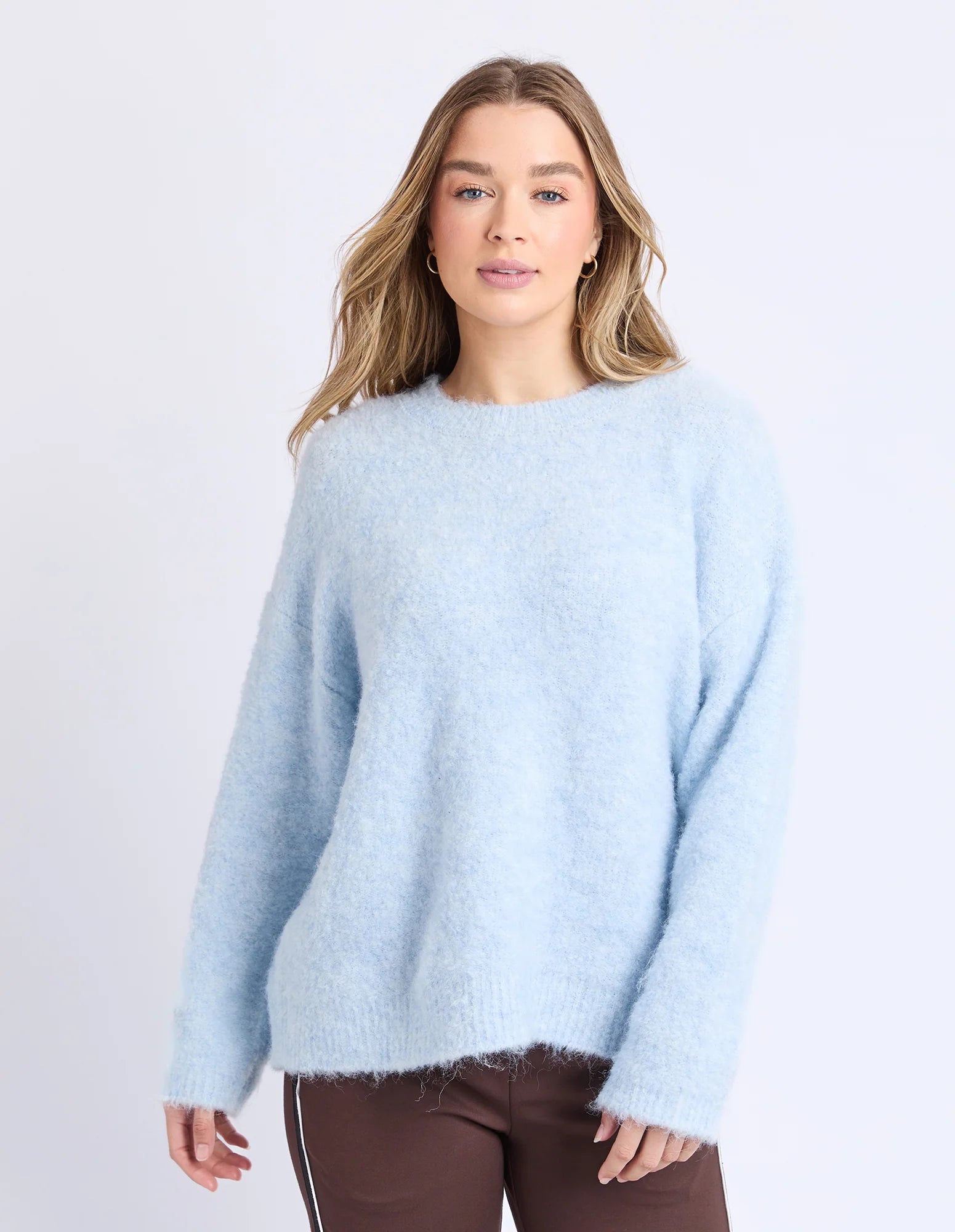 Woman wearing a Foxwood light blue sweater against a plain background