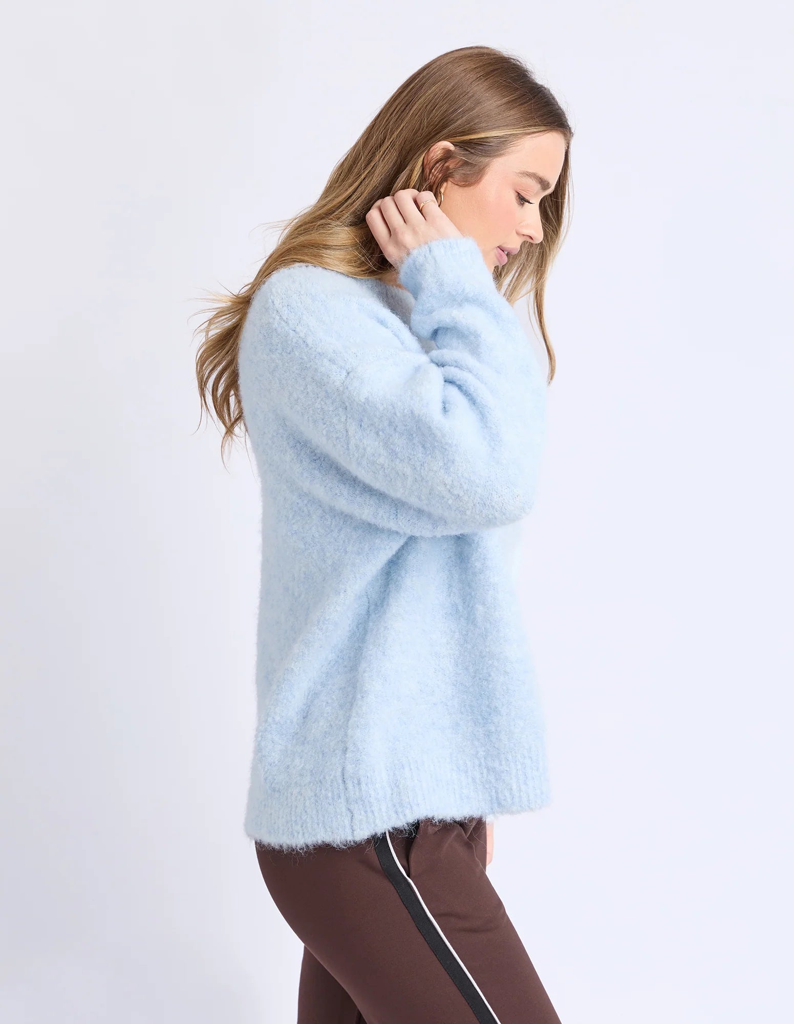 Woman wearing a Foxwood light blue sweater on a white background