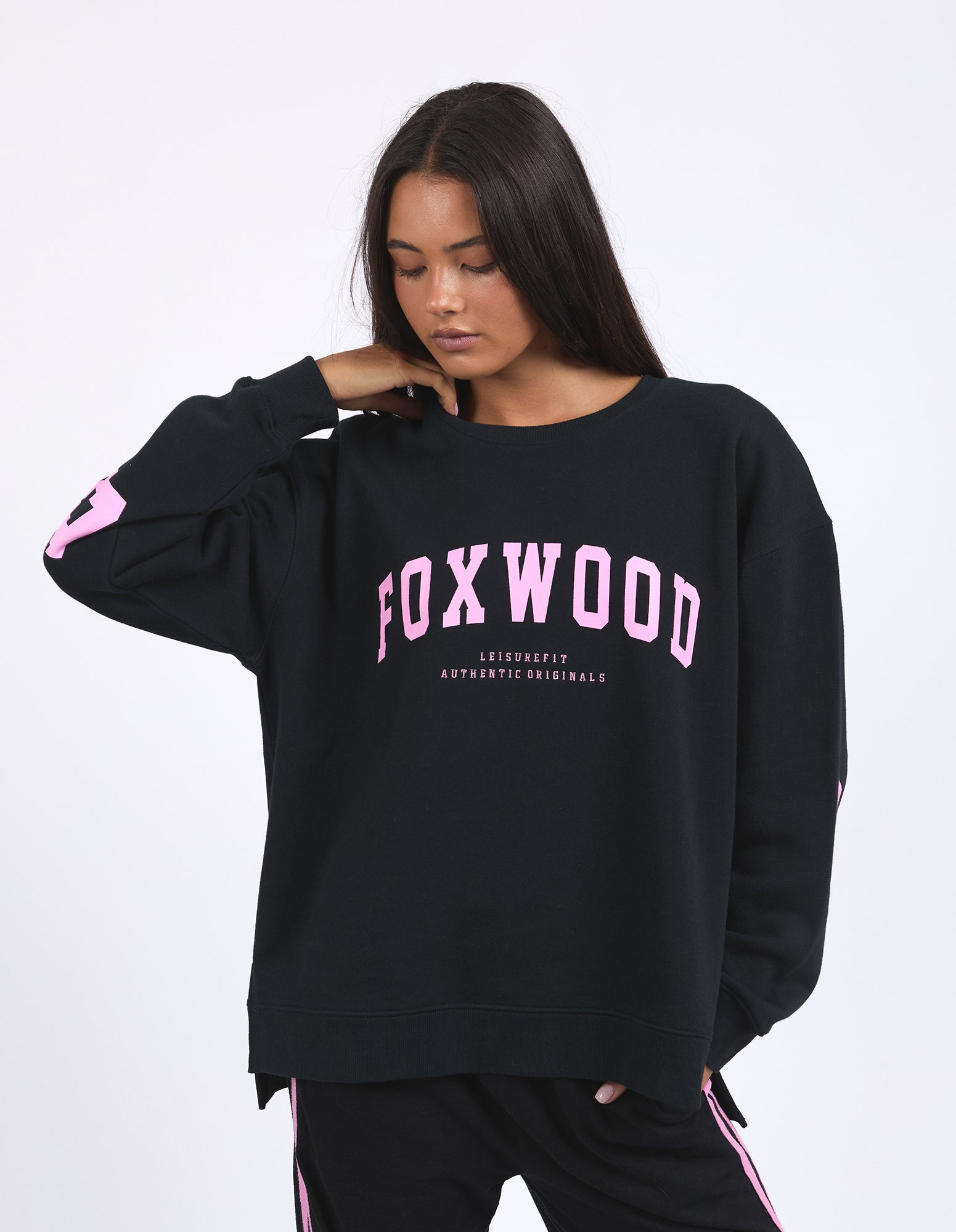 Image of Woman wearing a black sweatshirt with pink text on a white background