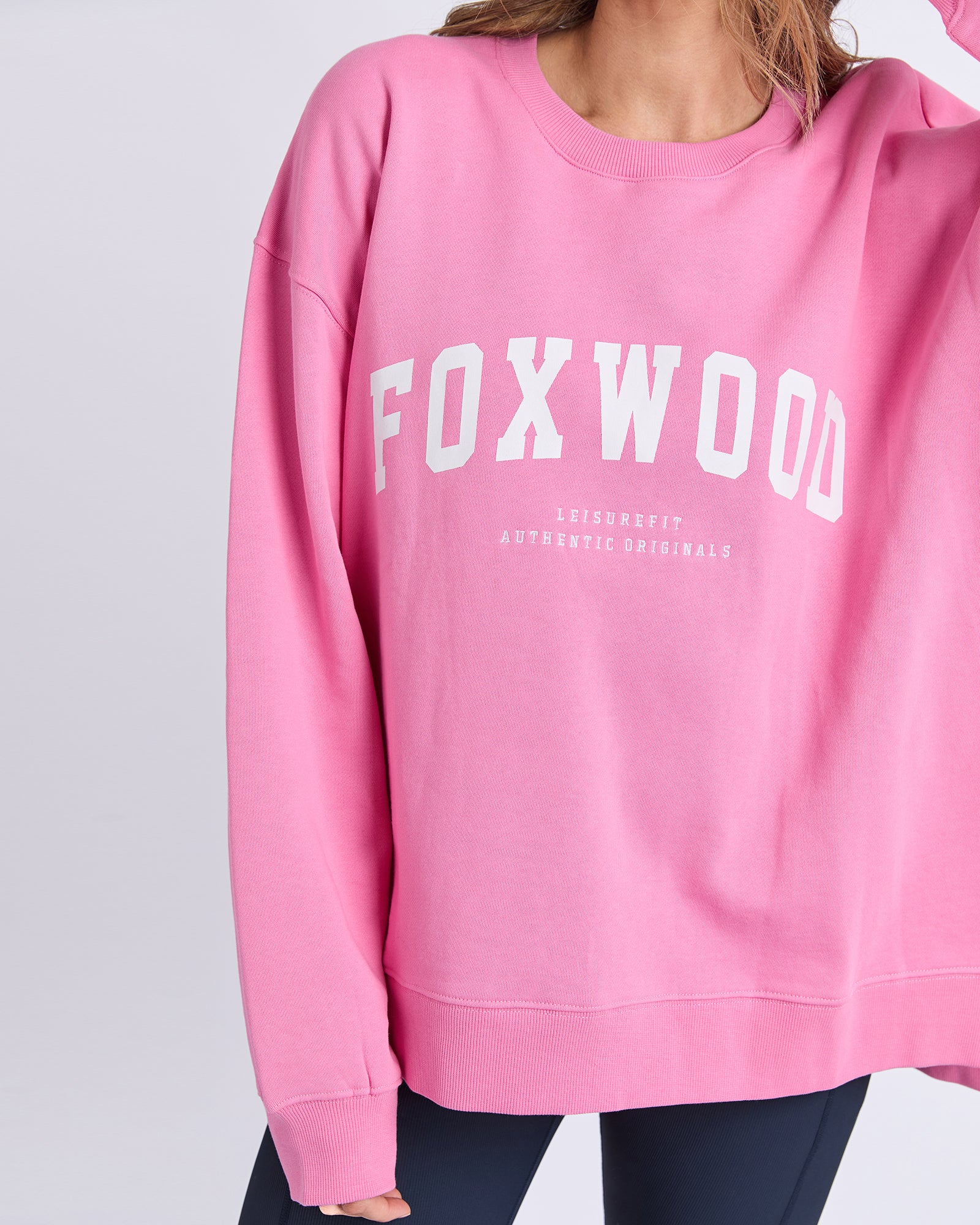 Pink Foxwood sweatshirt with 'FOXWOOD' printed on it against a light gray background