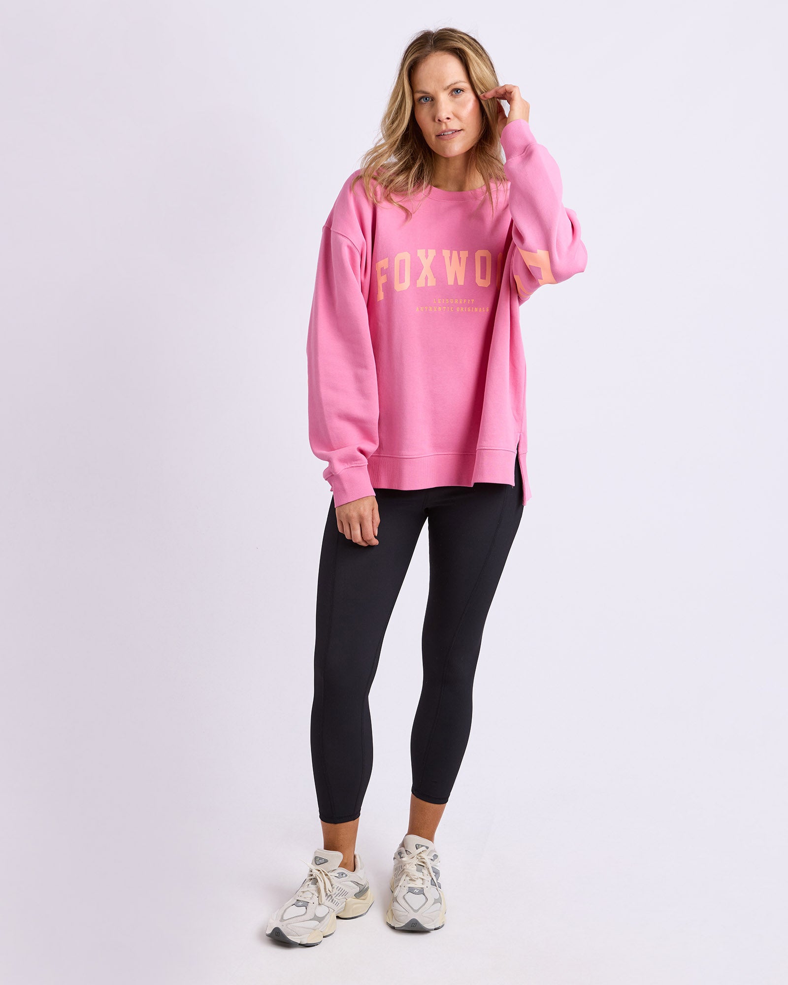 Woman wearing a pink sweatshirt with 'FOXWOOD' branding on a white background