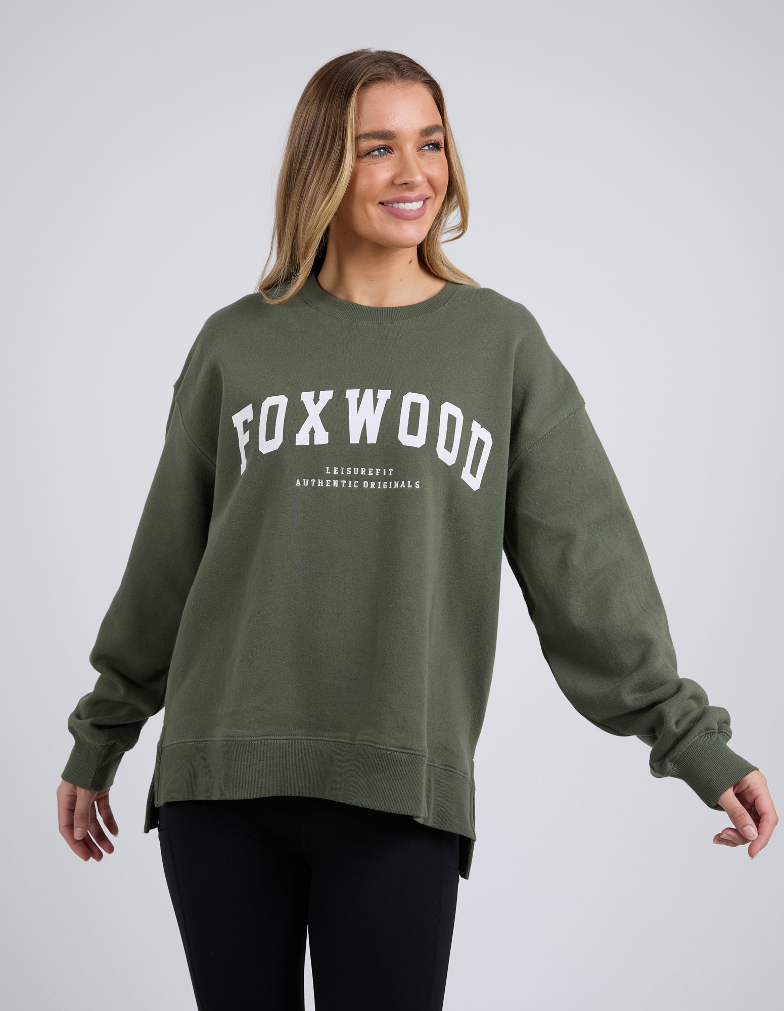 Image of Woman wearing Foxwood khaki crew on a white background with black leggings