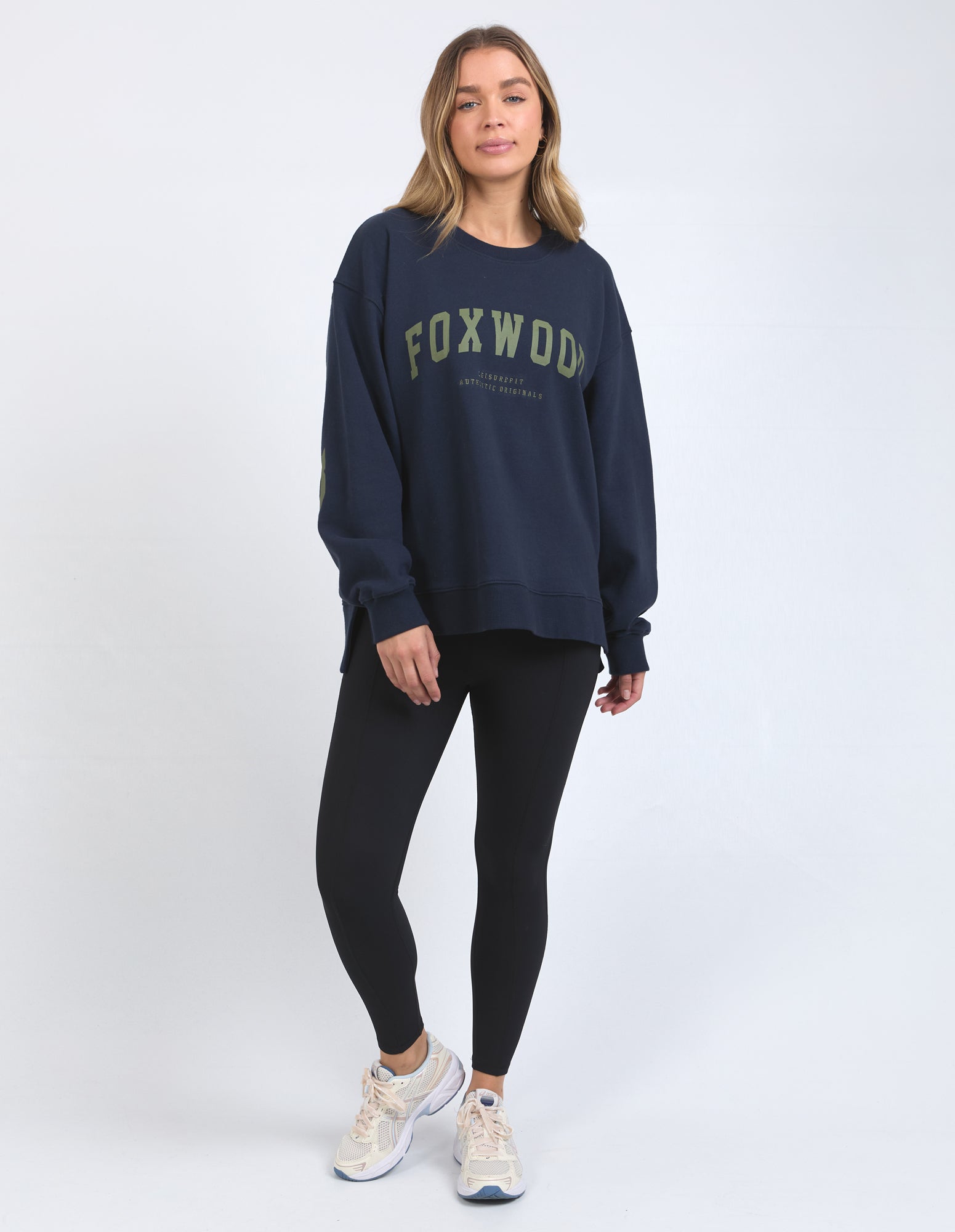 Image of Woman wearing a navy sweatshirt with 'FOXWOD' text on a white background