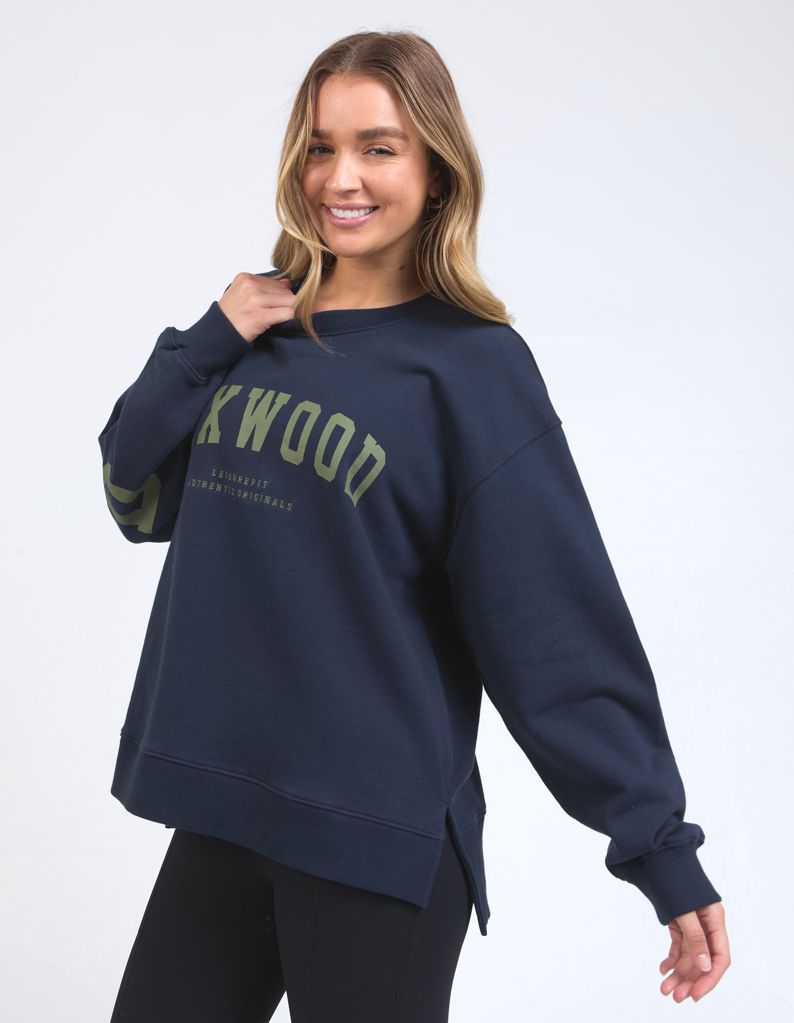 Woman wearing a navy blue sweatshirt with 'Foxwood' branding on a white background