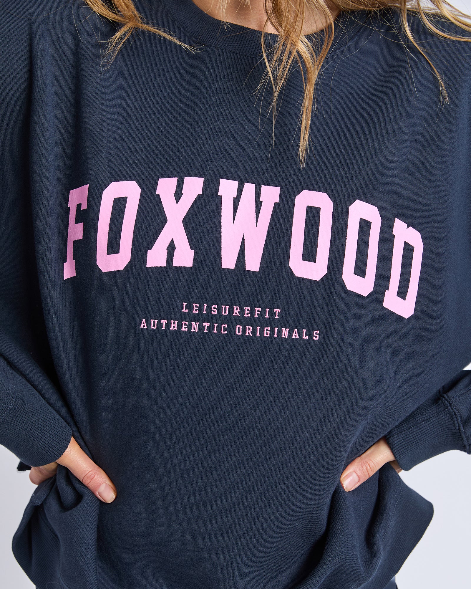 Image of Navy blue sweatshirt with 'FOXWOOD' printed in pink on a white background