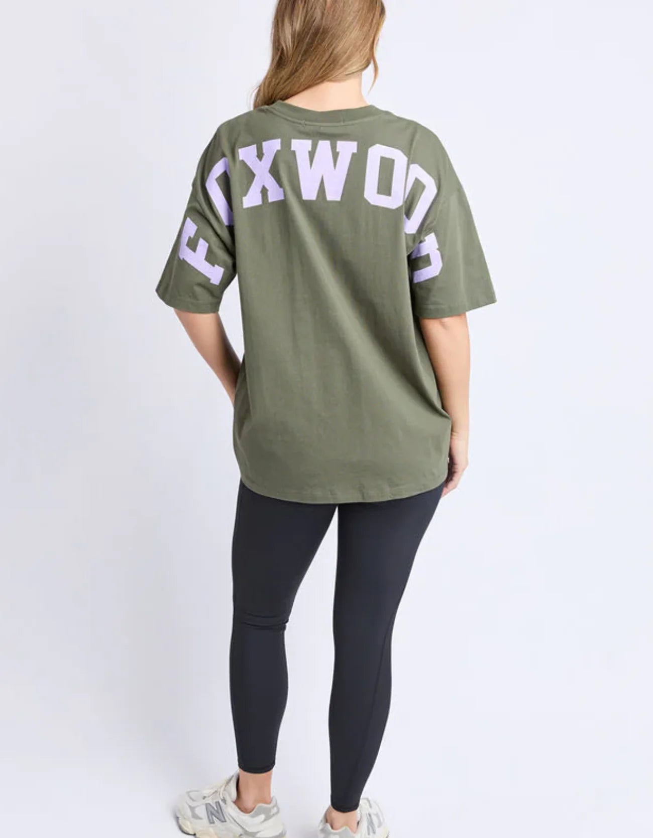 Person wearing a Foxwood olive green t-shirt with 'FOXWOOD' printed on the back, standing against a white background.