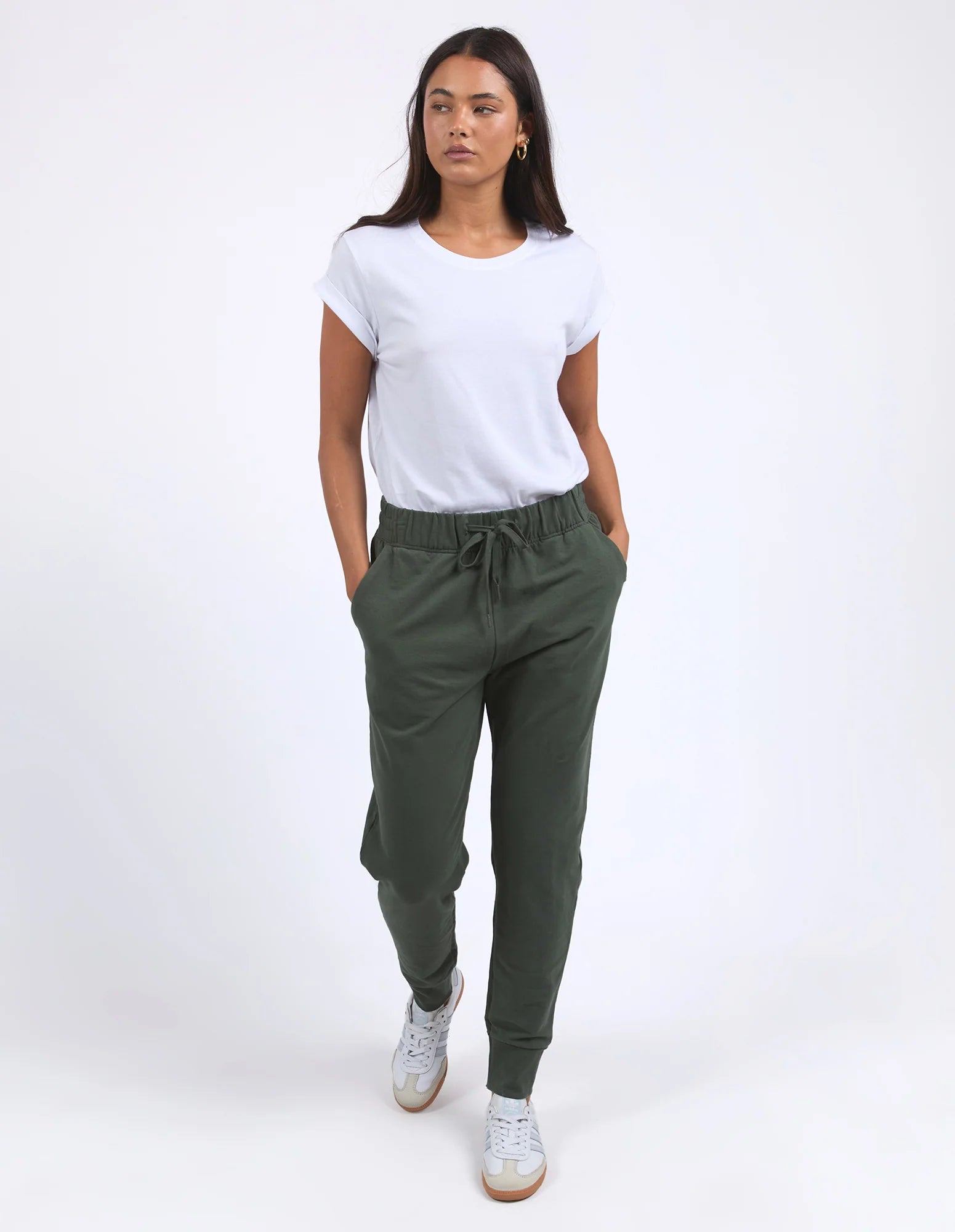 Image of Woman wearing a white t-shirt and Foxwood green jogger pants on a white background