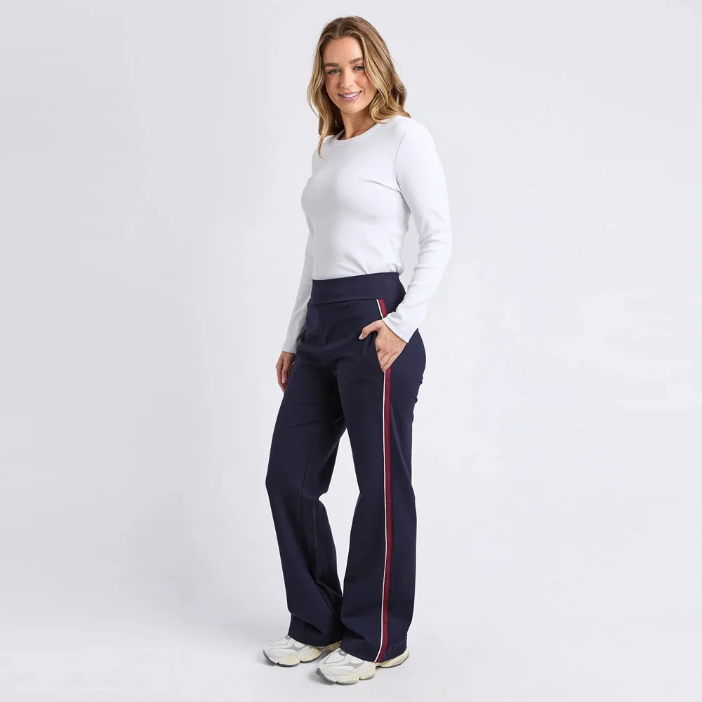 Woman wearing Foxwood navy pants with a red stripe on a white background