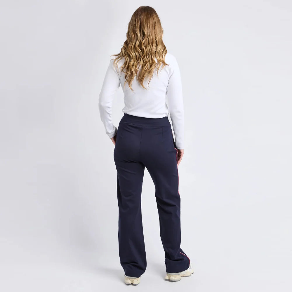 Woman wearing Foxwood navy pants and a white shirt on a light gray background