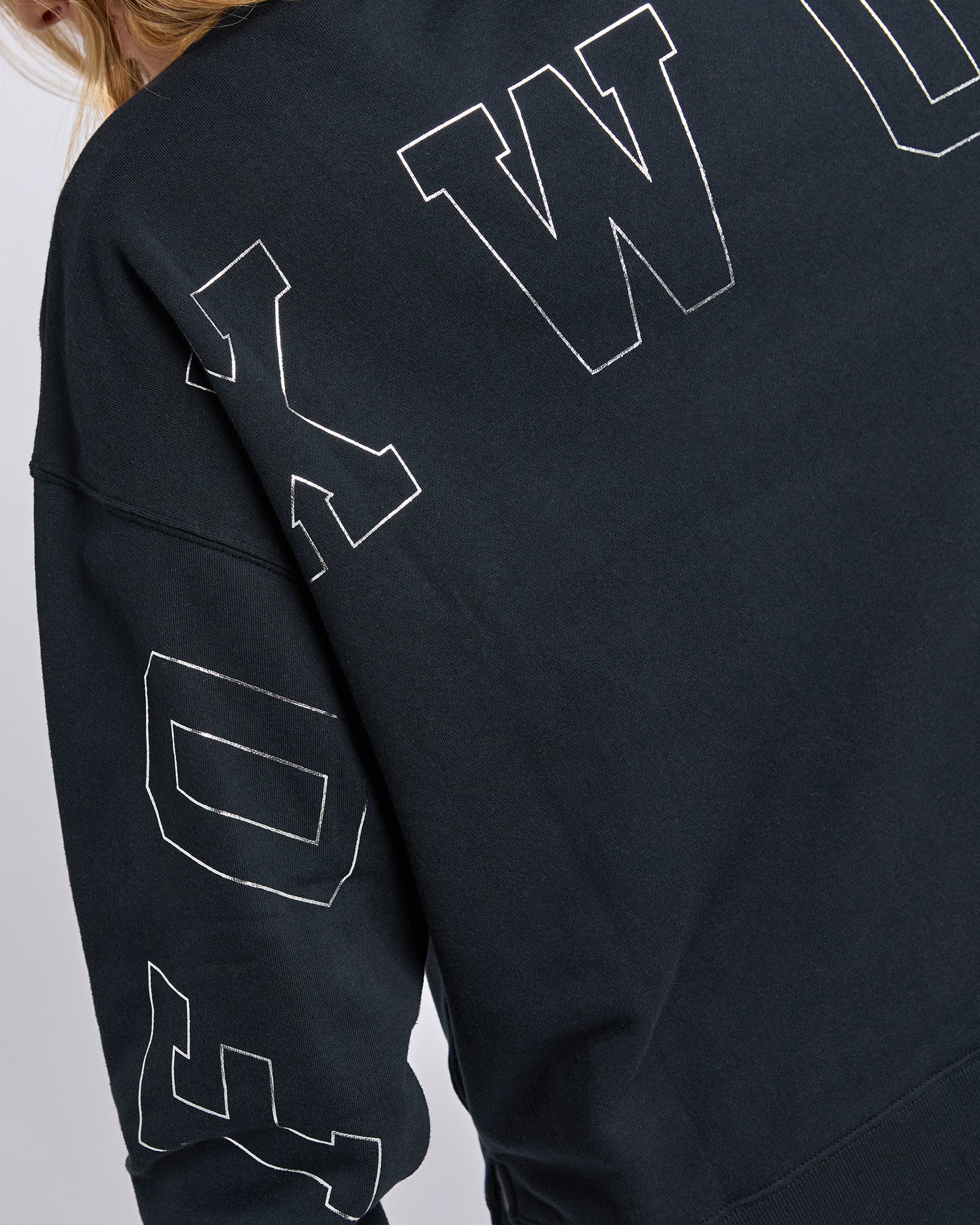 Woman wearing Foxwood Black sweatshirt with white text on a plain background