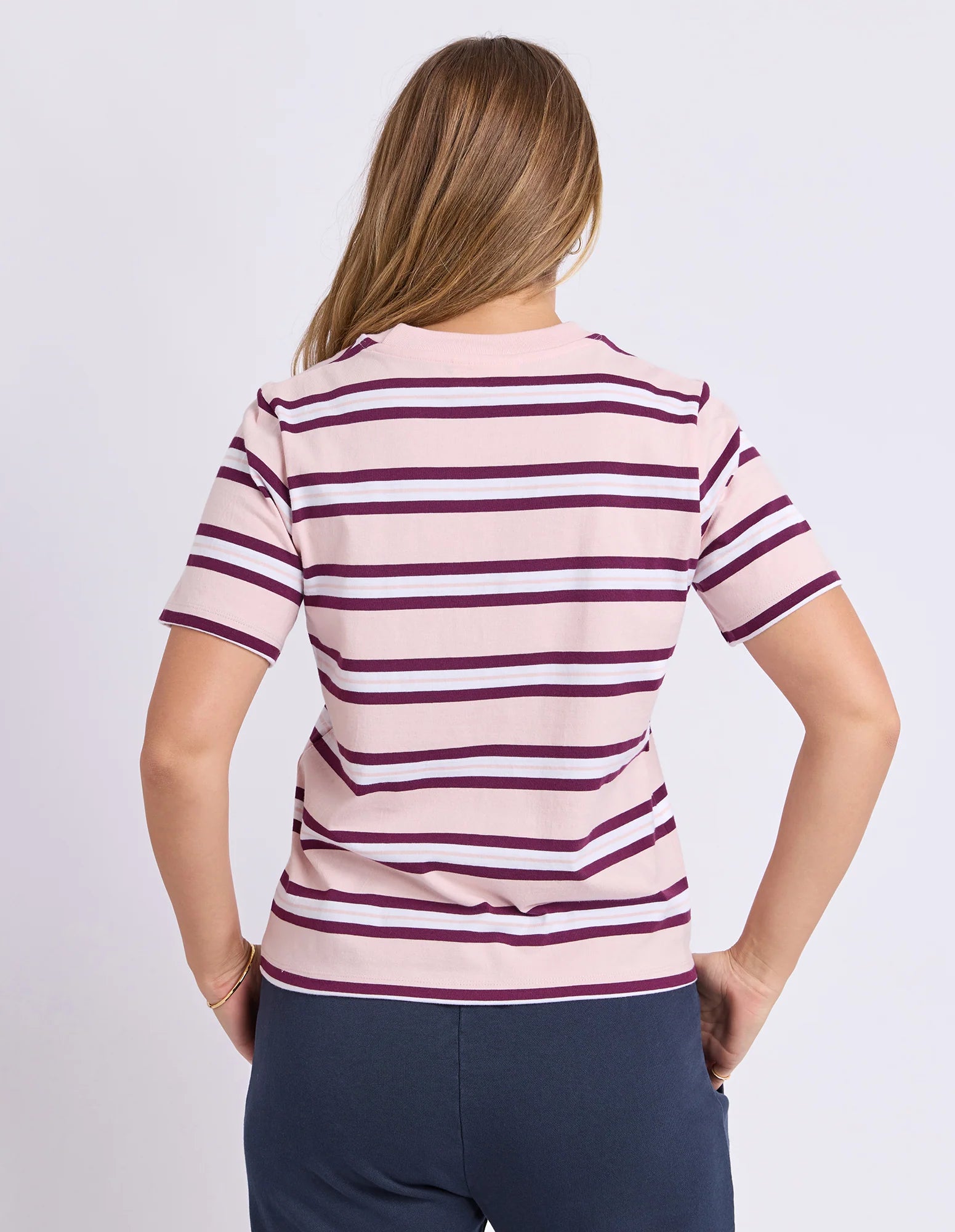 Image of Woman wearing a Foxwood pink and purple striped shirt on a white background