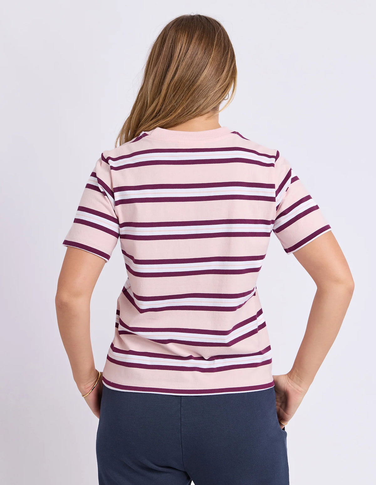 Woman wearing a Foxwood pink and purple striped shirt on a white background