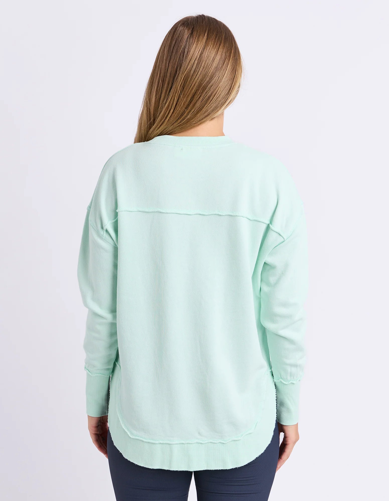 Image of Woman wearing Foxwood simplified crew in a pale mint colour paired with navy bike shorts on a plain background