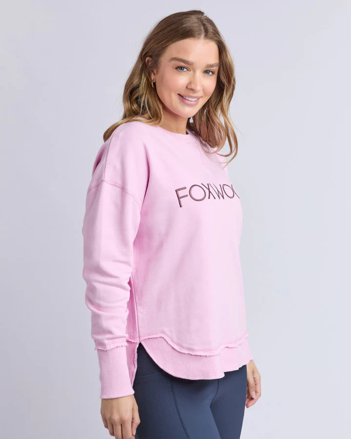 Woman wearing a pink sweatshirt with 'FOXWOM' text on a light gray background