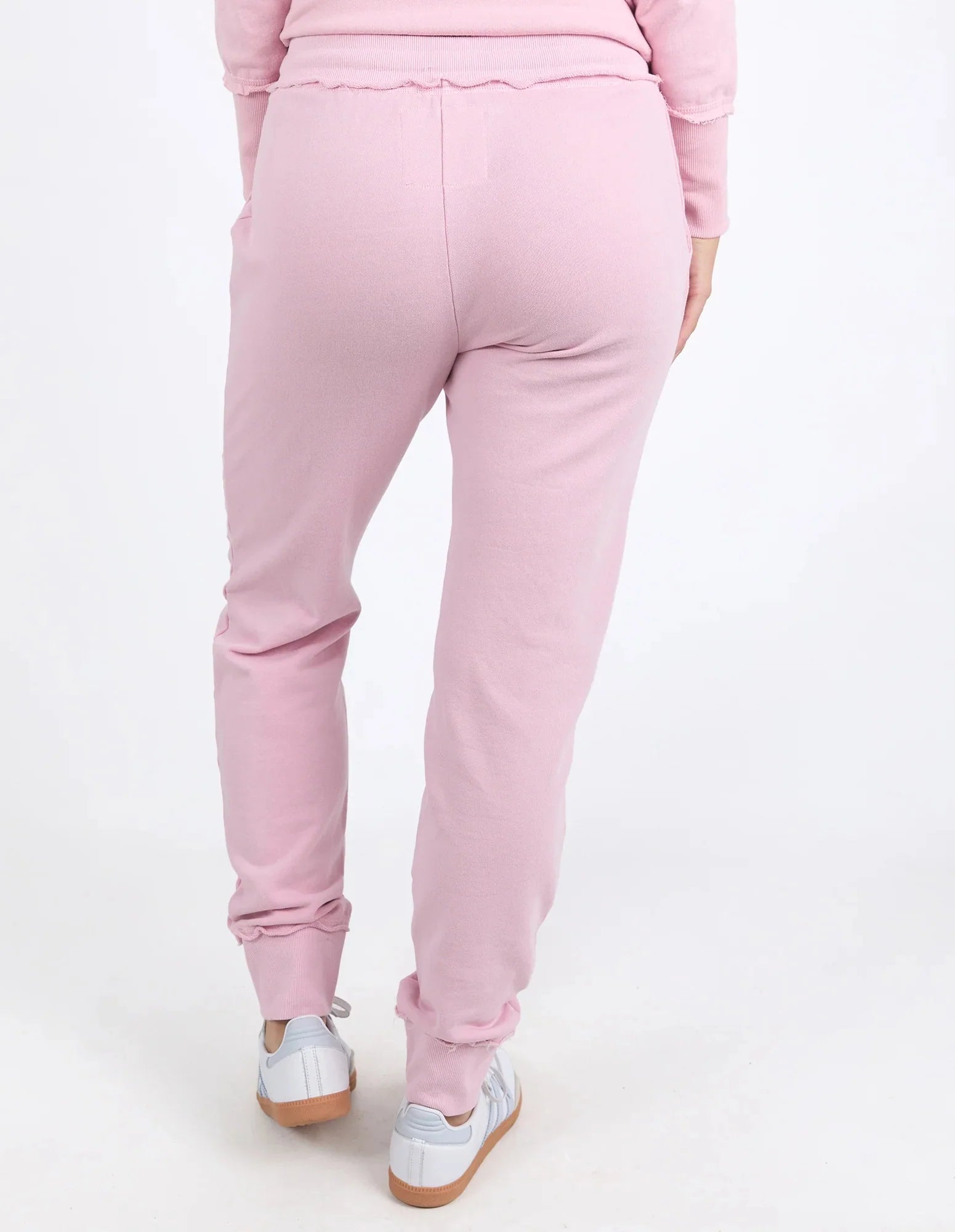 Image of A woman shown from the back wearing Foxwood light pink jogger sweatpants with a matching top and white sneakers, photographed against a clean white studio background.