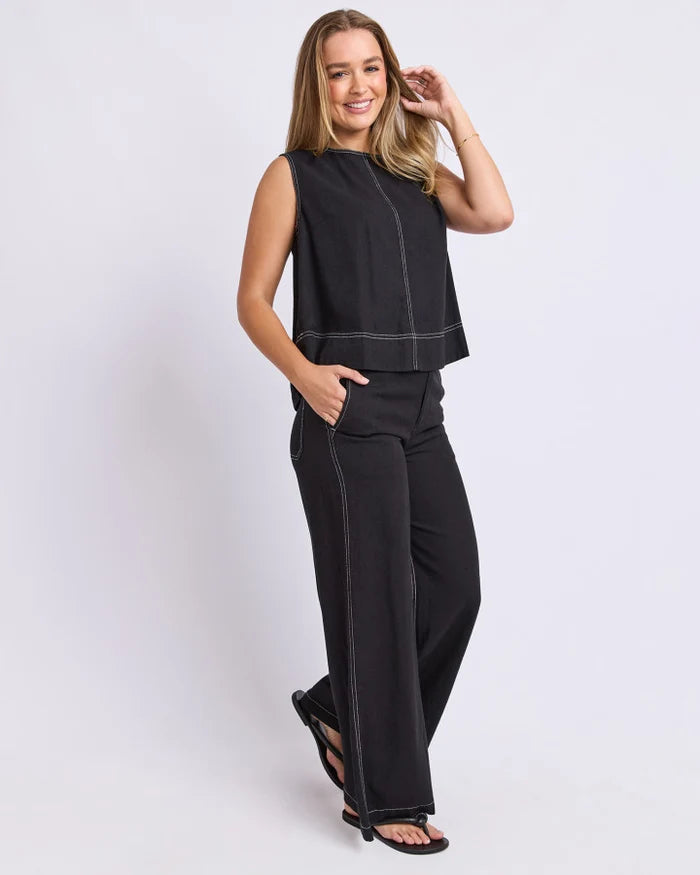 Woman wearing black Foxwood wide leg pants paired with a plain top on a plain background