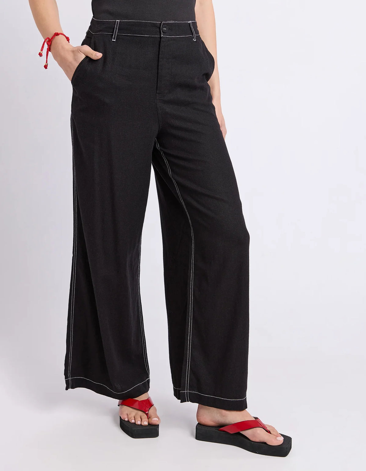 Woman wearing black Foxwood wide leg pants paired with a plain top on a plain background