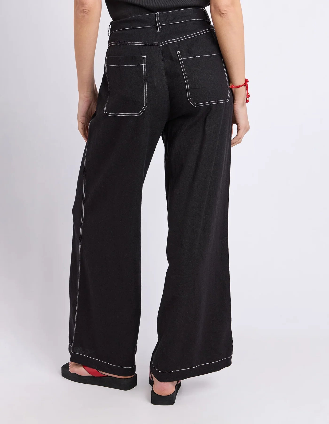 Image of Woman wearing black Foxwood wide leg pants paired with a plain top on a plain background