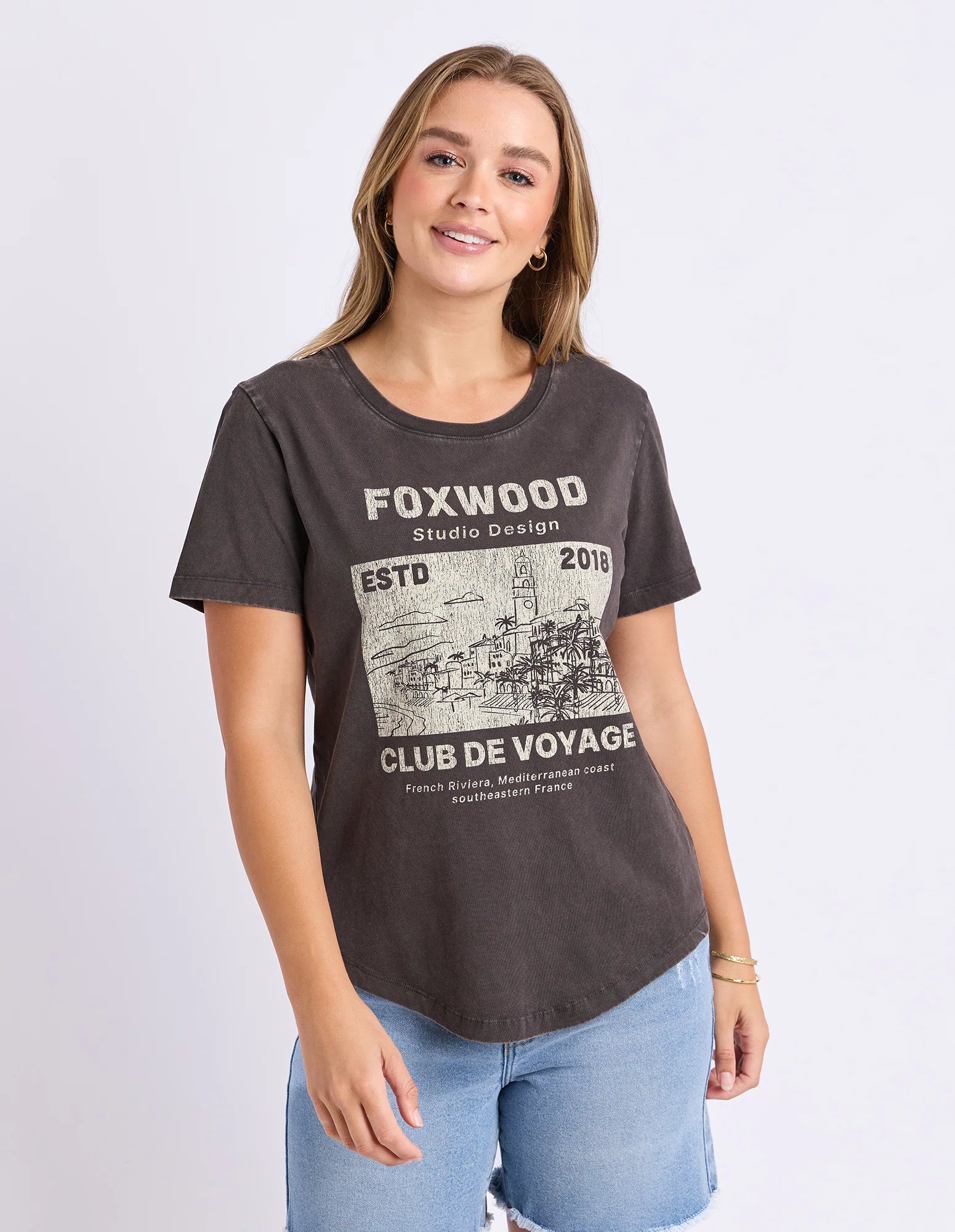 Image of Woman wearing a Foxwood black printed graphic t shirt paired with denim jeans on a plain background