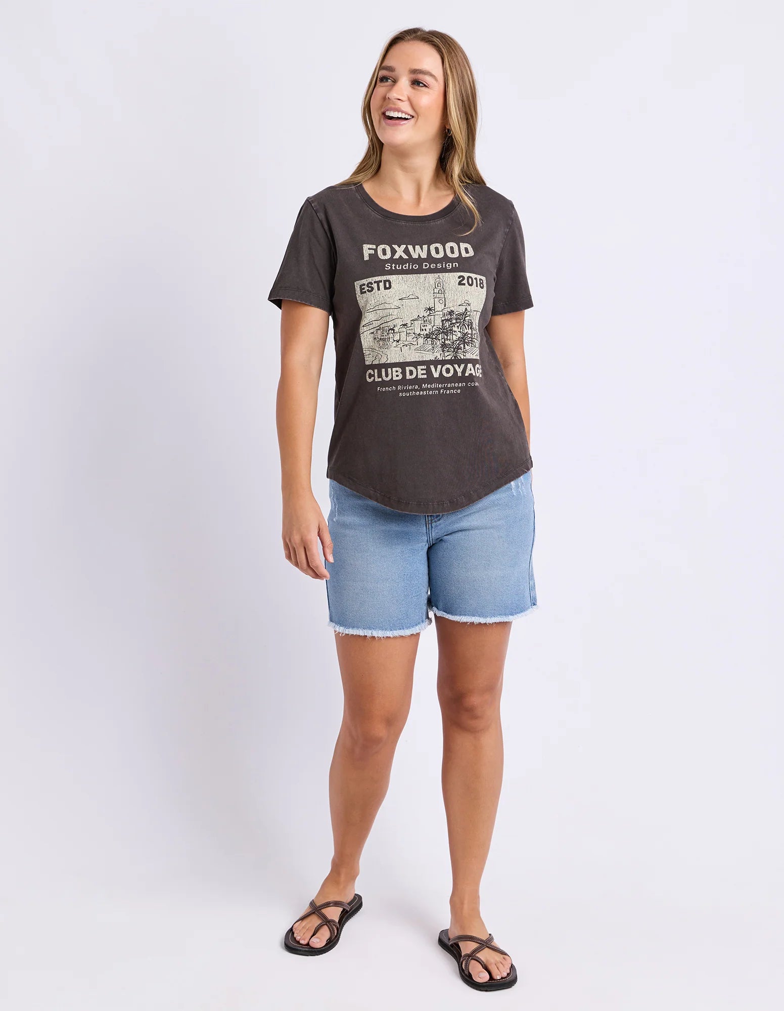 Image of Woman wearing a Foxwood black printed graphic t shirt paired with denim jeans on a plain background